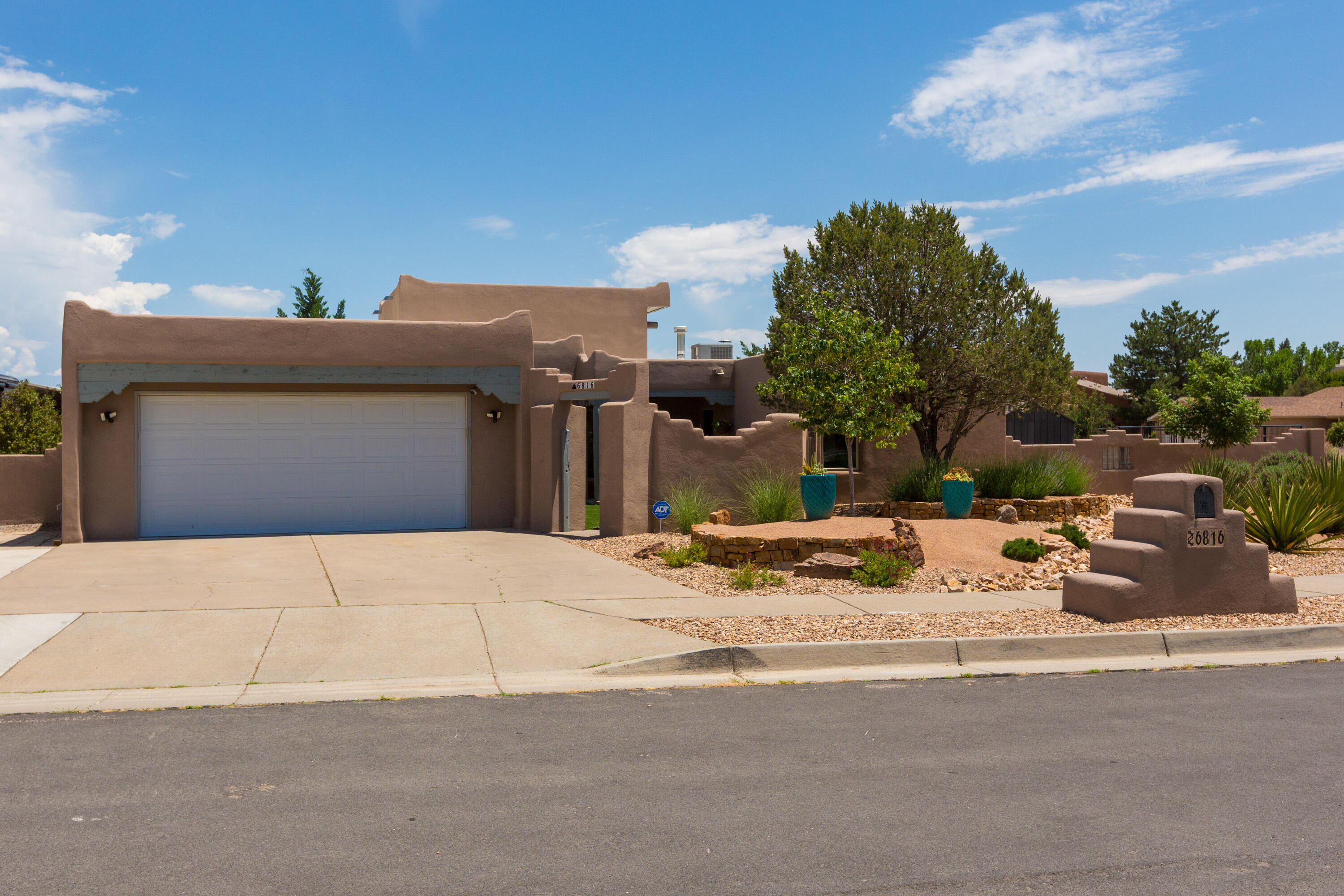 Be captivated by the warmth and charm of traditional Southwest architecture, including wooden viga ceilings, brick floors, a kiva fireplace, and smooth plaster-finish walls. The kitchen overlooks the open living area and features quartz countertops, cherrywood cabinets, stainless steel appliances, and top-of-the-line finishes that ensure comfortable modern living. Large windows fill the space with natural light while framing views of the beautifully landscaped lawn. This home offers three generously sized bedrooms, including a spacious primary suite with a spa-like bathroom. Multiple living areas open to the backyard, where a large covered patio provides a perfect space for entertaining. The expansive lot includes a front RV pad with hookups and side yard access for storing all your toys.