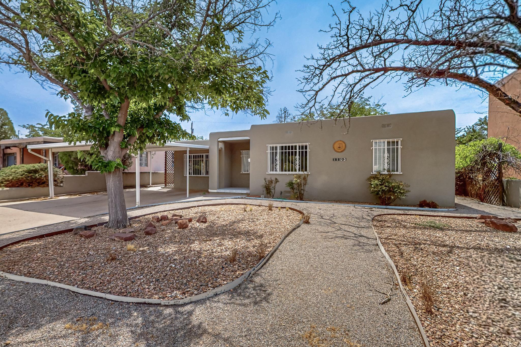 This charming 3-bedroom home in the Ridgecrest neighborhood greets you with a cozy covered front porch and easy to maintain landscaped front yard.  Its light-filled interior features classic details like coved ceilings and hardwood flooring. With its double-pane vinyl windows, the home blends timeless charm with modern comfort. You'll love the natural light that fills the kitchen, creating a bright and welcoming space. The generously sized laundry room adds convenience and comes complete with a washer and dryer.Step outside to a private, oversized backyard. Landscaped and perfect for entertaining, complete with a covered patio and extra storage. Located in the desirable Ridgecrest neighborhood with easy access to freeways, UNM, Kirtland AFB, hospitals, restaurants, and more.