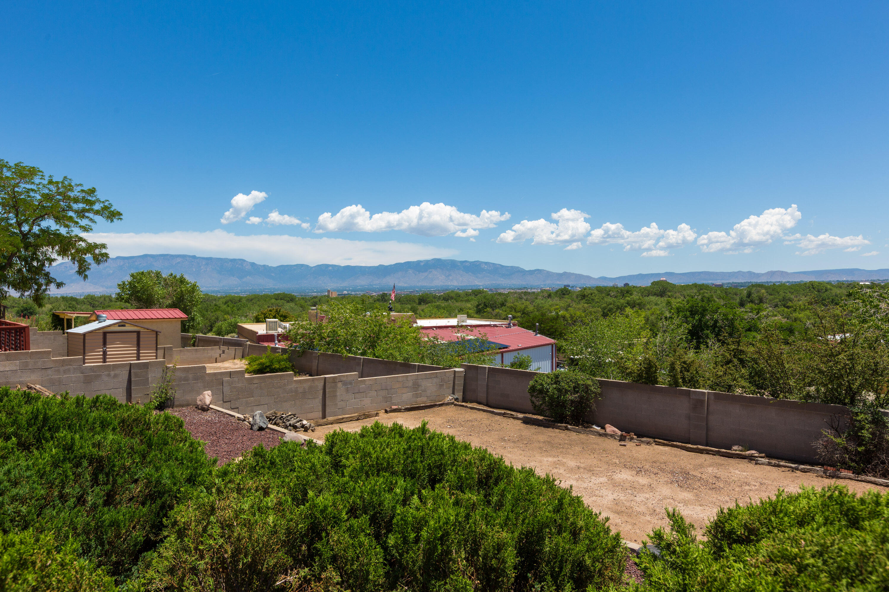 Watch the ''magic hour'' sunsets over the Sandia Mountains from your back patio or enjoy the spectacular view of the mountains from the living room, kitchen, or primary bedroom. The house has a versatile floorplan with two living areas and a formal dining room offering space for a 4th bedroom and home office! New roof, gutters, rain barrels, ceiling fans, kitchen light, plus a freshly serviced cooler means the house is ready for you to move right in make it your own. Seller is even offering a $5,000 credit to help you realize your dream.