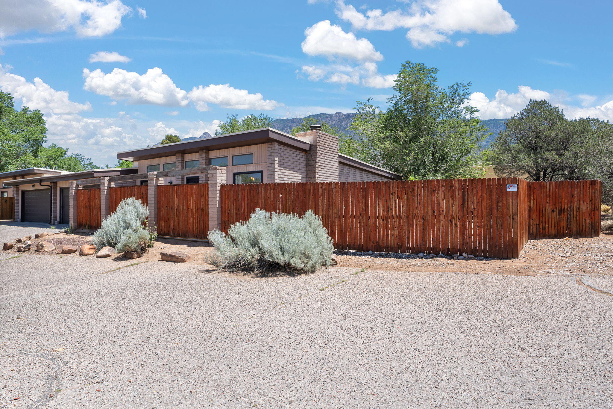 Charming 1 story, 2 bedroom, 2 bath  home in private cul de sac in exclusive Sandia Heights!  This could easily be two large master suites.  Incredible Air BnB potential!  Large bathrooms could be adapted for handicapped accessibility.  Brand new TPO roof with 20 year warranty!  Large fenced private corner lot with trees and raised herb garden blocks  in back.  Cathedral ceilings in two car garage for incredible storage.  No carpet.  Laminate and slate flooring greet you.  Radon mitigation already in place! Refrigerated air!  Cozy wood fireplace for relaxing in the evening. All appliances remain with home including refrigerator, washer and dryer.  Just walk outside, and the trails meet you!