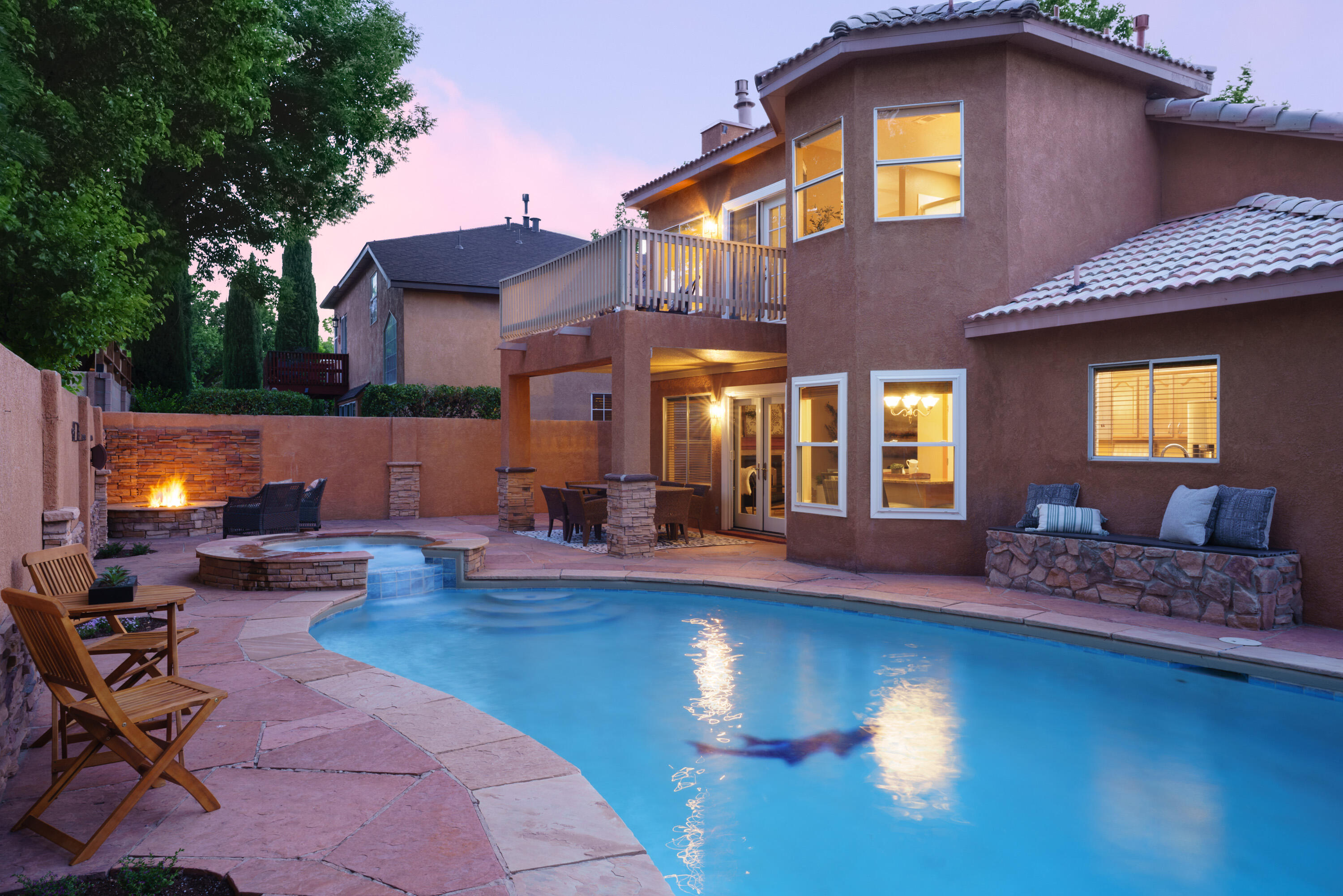 Cool off all summer long in your own resort style backyard featuring a custom heated pool, hot tub, grill, fire pit, & covered patio. Also, backyard access for your RV, boat, trailer. Inside there are two living spaces, an updated kitchen with dovetail cabinetry, stainless steel appliances, & granite counters. Upstairs beautiful wood look tile flooring and a view deck off the primary suite. Located one block from a Piedras Marcadas Trailhead connecting to the Rio Grande Bosque, Petroglyph National Monument, and Mariposa Park. Easy access to groceries and restaurants off of Coors & Paseo!