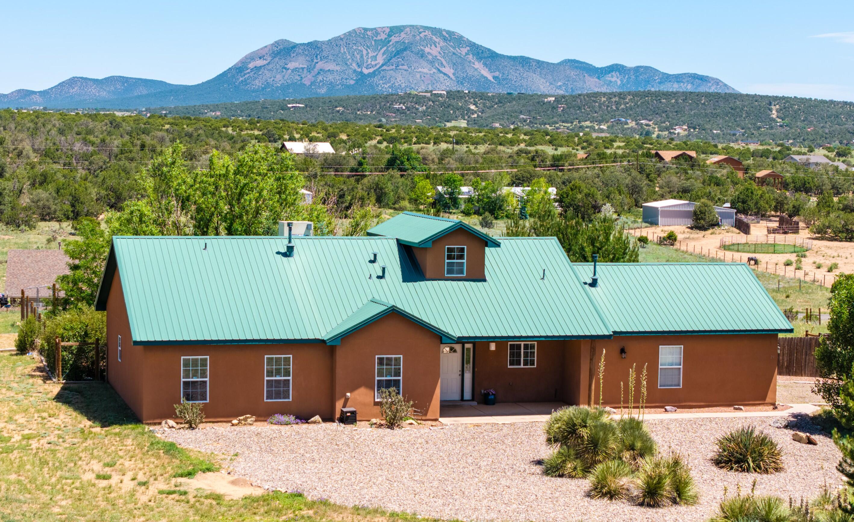 Get ready to fall in love with this delightful Northern New Mexico home that perfectly blends comfort and style! This one-story beauty features a picturesque covered front porch, ideal for lazy afternoons, while the expansive 30' X 19' covered back patio with a charming vine-covered arbor is just waiting for your next barbecue bash. With three bedrooms plus a dedicated office, you'll never be short on space. The primary suite dazzles with a huge walk-in closet and  en-suite bath. Bright and airy with cathedral ceilings, the open layout and low-maintenance tile and concrete floors are designed for easy living and entertaining. Plus, your furry friends will appreciate the fenced yard! Located with easy access to I-40 and just a short drive to shopping in Edgewood.