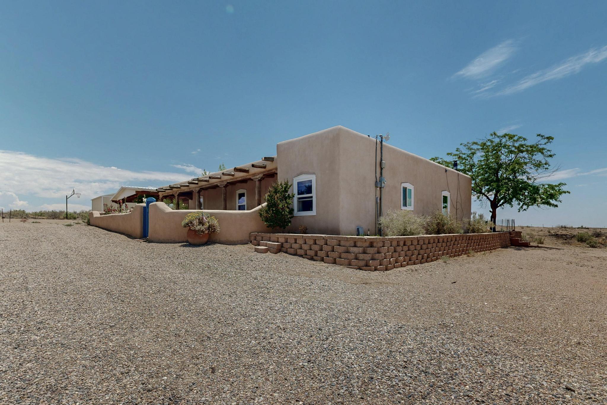 Cool summer days in this Adobe 4 bedroom, 2 bathroom home.  In addition you have a 565 sq.ft. casita with 1 bedroom and 3/4 bathroom.  The 10 acres is divided into two 5 acre lots. Possible future home site? Peace and quiet with spectacular views of the Rio Grande valley along with incredible southwest charm. The living room, dining and kitchen are filled with warm wood  exposed vigas and wood ceilings and a cozy fireplace for cold winters. The front courtyard is in bloom and welcoming. The kitchen has custom island  and generous counter space with kitchen appliances. Additional 9 acres to east listed MLS#086263