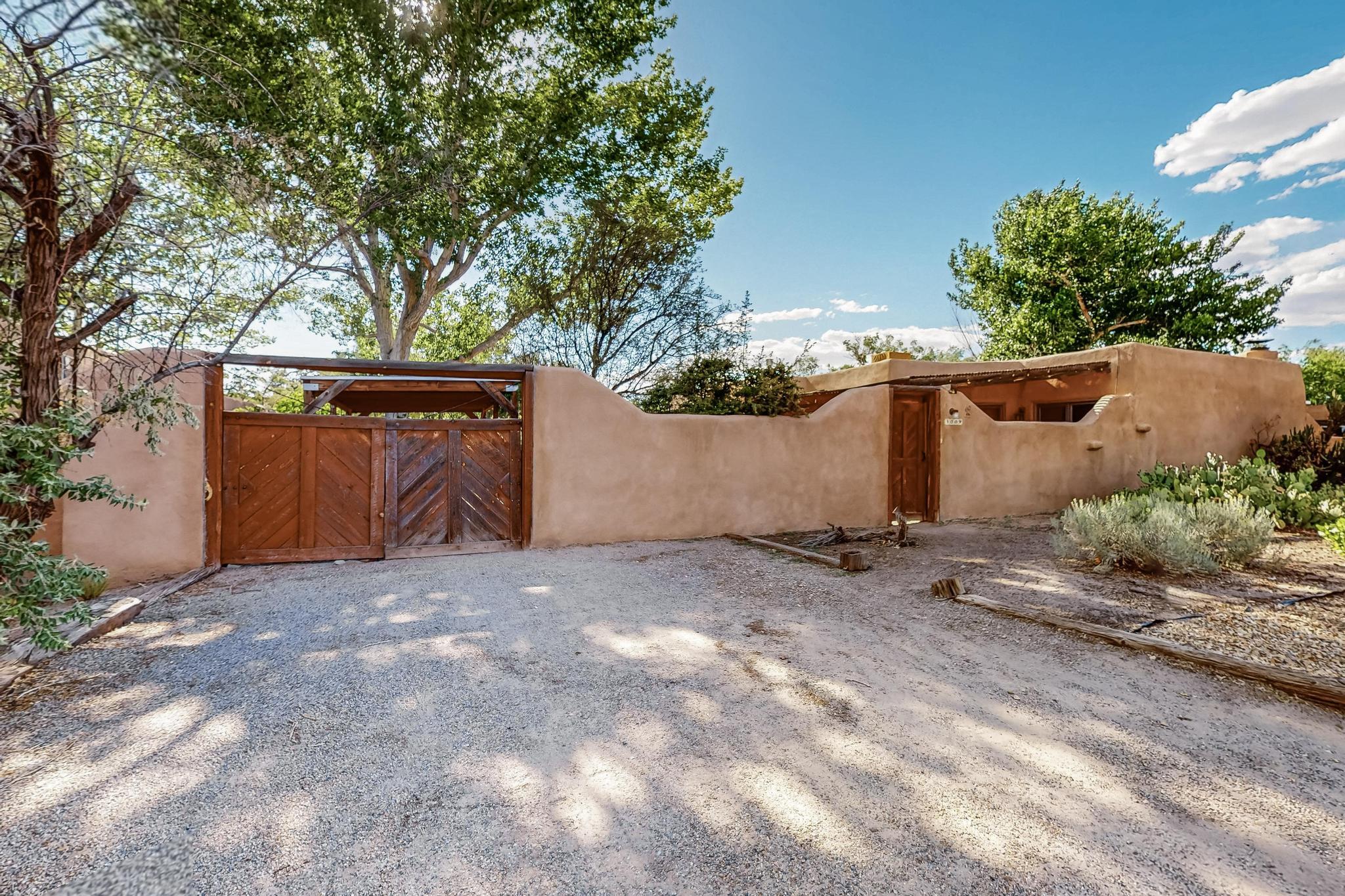 Secluded North Valley home near Rio Grande NW. Tall, walled courtyard with mature landscaping. Adobe home with mostly brick floors, fabulous vigas throughout and SW kiva fireplace. Desirable location North of Old Town on close-ended street. Hap Crawford was famous architect/builder. Private, walled courtyard with mature landscaping. Master bedroom opens to courtyard. Beautifully carved front door. Lots of natural light from big windows and skylights. Radiant floor heating. Close to restaurants, shopping, central ABQ.
