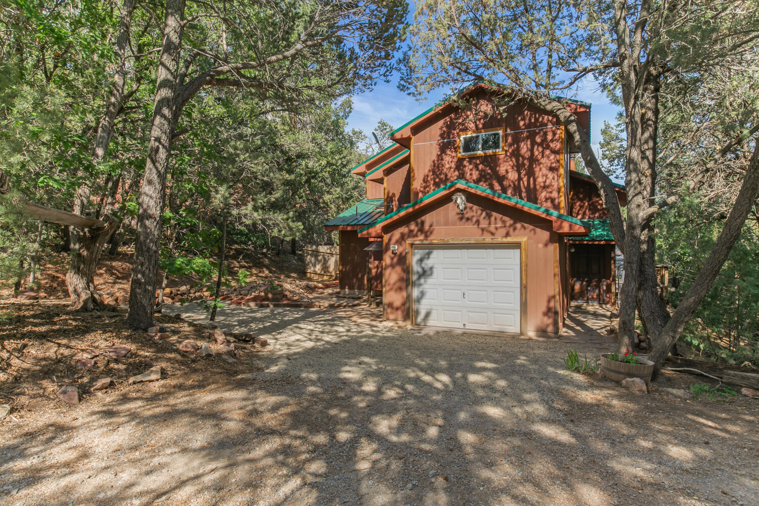 Wonderful home located in the highly desired Sandia Crest area!  This light-filled property features: Tongue & groove vaulted ceiling, Bar seating in kitchen & custom steel cabinet detail, Brick & wood floors, Pellet stove, 2+ living areas w/ flexibility of one being a den, hobby room or office w/ a separate entrance, Spacious primary bedroom w/ large  walk in closet, Huge deck (perfect for star gazing!) & fenced yard w/ views of the beautiful, mature ponderosa pines and array of trees, Attached storage area plus a storage shed, Metal roof & new septic system (May 2025) complete this beauty!  Amazing location just minutes from hiking/biking trails, Sandia Peak, Sandia Peak Ski Area & the Cibola National Forest.  Don't miss this opportunity!