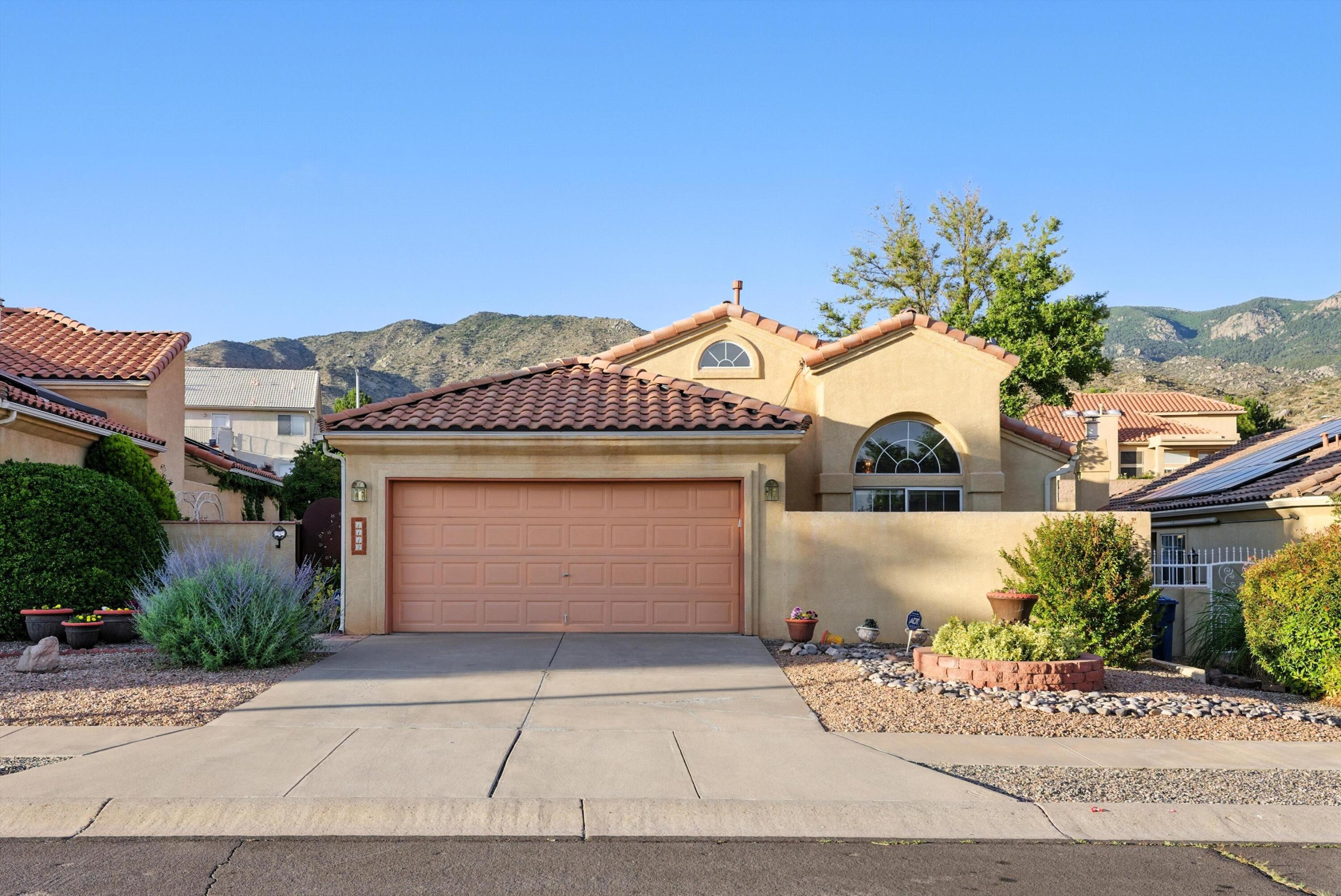 VIEWS, CHARACTER, COMFORT--THIS HOME HAS IT ALL. Nestled near the base of the Sandias, this 3-bedroom, 2-bath gem welcomes you with a private courtyard and a sense of home that's both warm and grand. Very recent A/C replacement ensures you are cool all summer long! Custom details shine from the walk-in tub in the master, to the striking fireplace, to the spacious living and dining rooms. The open kitchen features a pantry and island, ideal for morning coffee or evening prep. The primary suite offers double sinks, the walk-in tub and shower, and patio access to your walled backyard oasis. Enjoy expert landscaping, mountain views, and nearby golf, trails, shopping, and dining. Come experience the Eastside lifestyle--schedule your showing today!