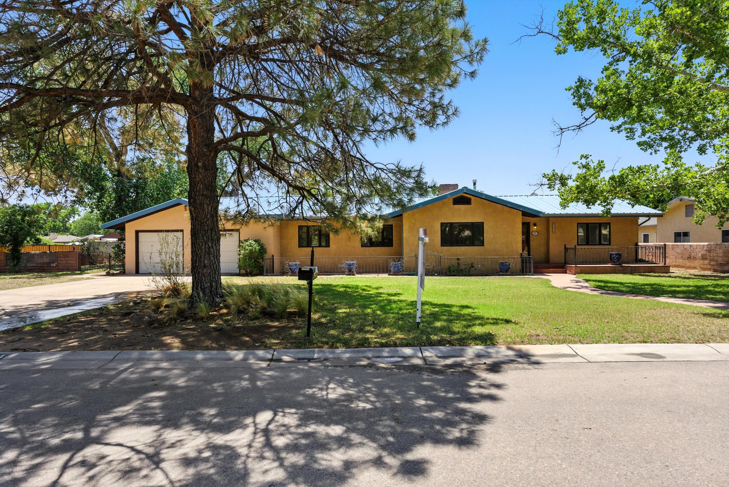 Welcome Home to Lee Acres in the North Valley.  Great opportunity to own a home that has been loved for a long time.This 3 bedroom plus flex room and 2 bath home is charming.  As you enter into the living  you are greeted with an inviting brick fire place that is gas assisted. Dining room with arched walls.  Spacious kitchen with a working island.  The addition is wonderful for entertaining - Cozy up to the wood burning stove in the sunken gathering room.  Room for a pool table or an additional living space/office. Relax in the hot tub in the serene courtyard off of the home.  This home offers OWNED SOLAR. Spacious yard almost half acre, with  carport and two storage buildings with side yard access.  This home has so much to offer and located in a sought after neighborhood!