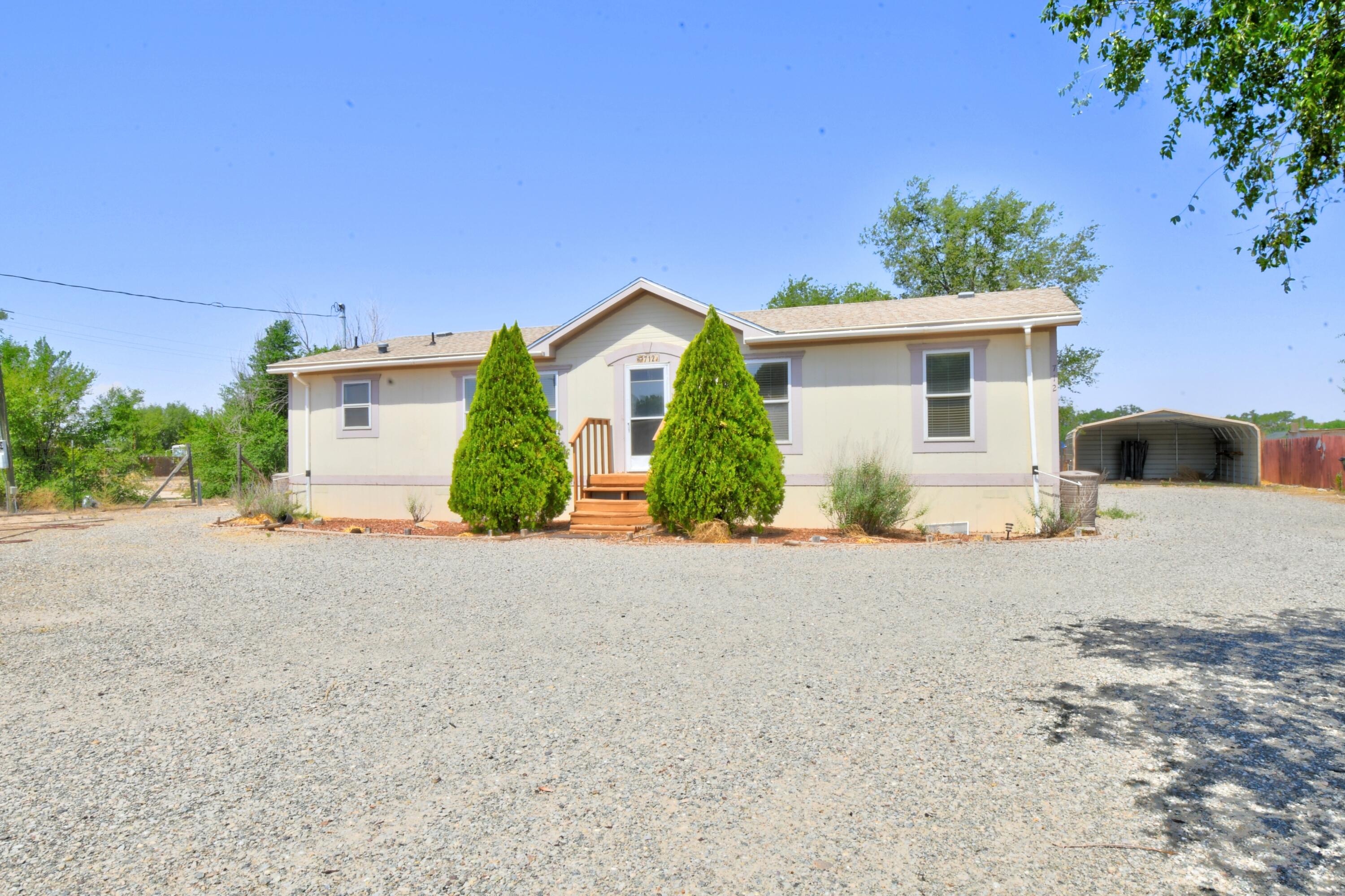 Welcome to your new home in Los Chavez! This charming 3-bedroom, 2-bath manufactured home offers an open-concept layout perfect for entertaining. The eat-in kitchen provides a cozy spot for meals, while a versatile flex space can serve as a dining room or home office. The primary bath features a relaxing garden tub, and the newly updated carpet adds a fresh touch throughout. Enjoy the oversized carport, spacious backyard deck for summer fun, and refrigerated air to keep you cool on hot days. Situated on a generous 0.5-acre lot, there's plenty of room for outdoor living and hobbies. Come see how comfort and functionality come together in this inviting home!
