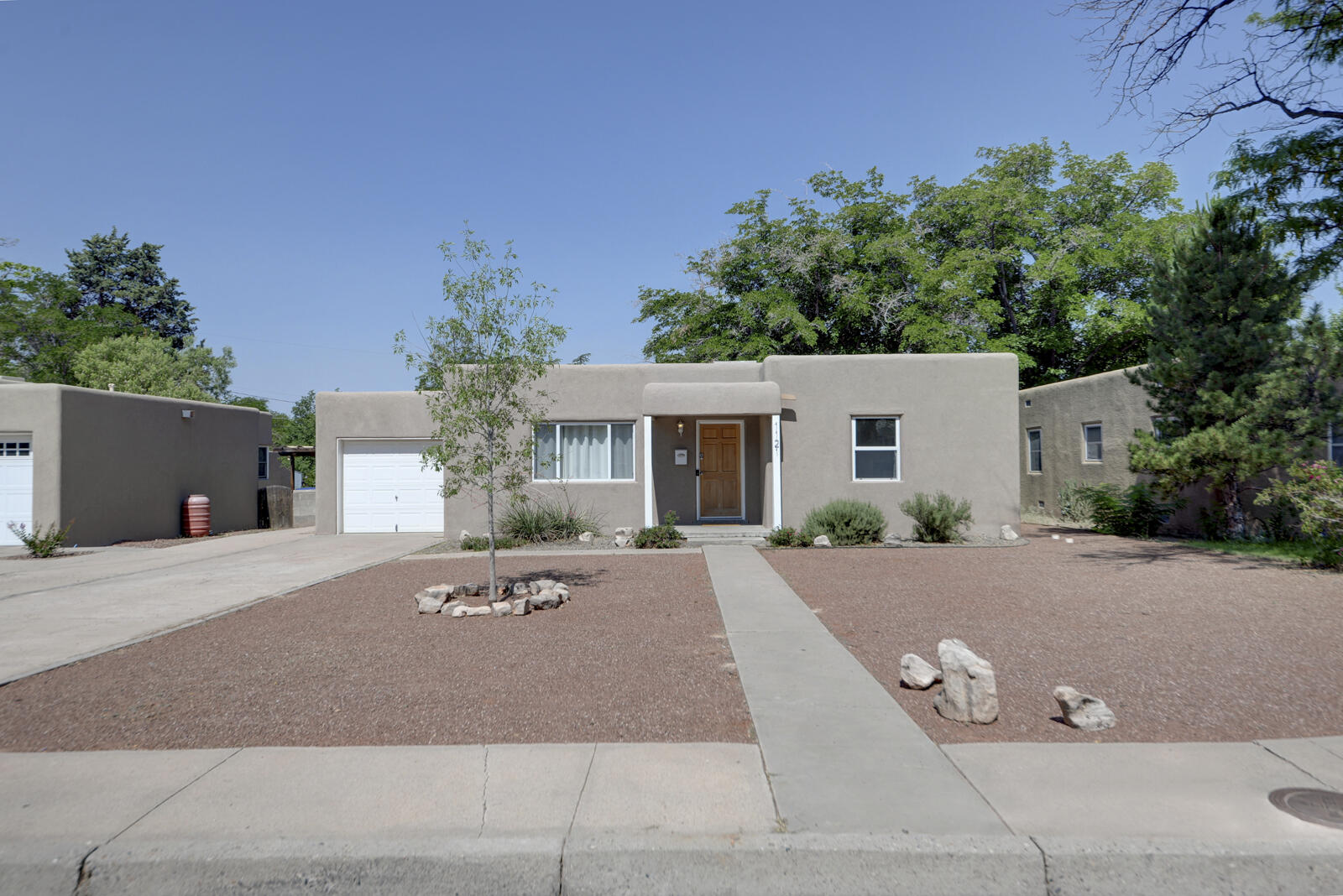 Charming Casa in popular Twin Parks/Hidden Park Neighborhood!  Move in ready - a true delight! Greatroom overlooks easy care front yard with eastern view towards Sandias! Cove ceilings & lovely hardwood floors combine with contemporary but classic black & white kitchen.  Bedrooms are generously sized offering double closet space - a welcome surprise for this vintage of home. Large laundry room + 3 more closets give ample space for all your needs. Backyard with fire pit and open patio is great hangout!.  No backyard neighbors just more open space - the benefit to this block of homes. UPDATES INCLUDE: stucco, windows, electrical service, sewer line, plumbing & light fixtures, front door, garage door opener, master cool, roof.  A great find so close to UNM, Whole Foods, Nob Hill & Parks!