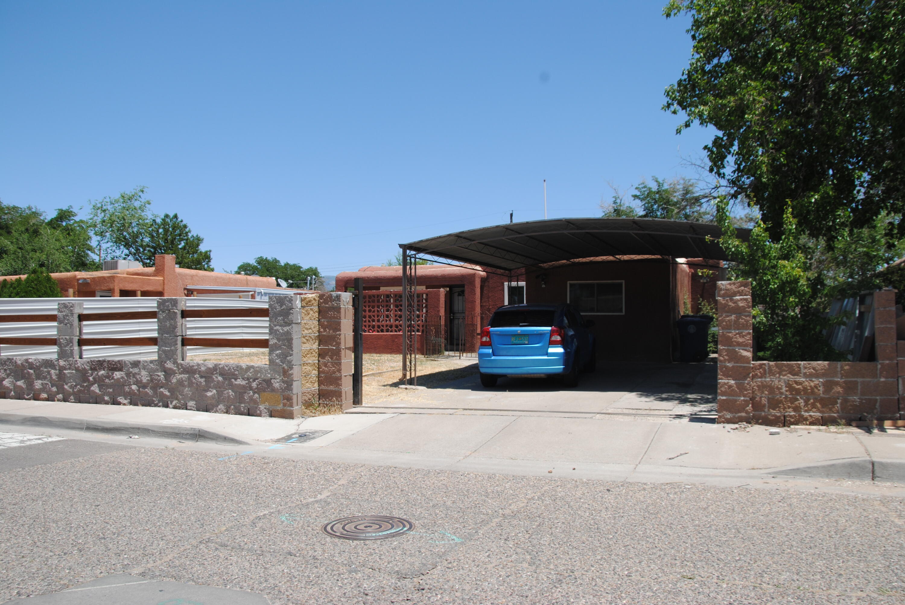 Introducing this 5-bedroom NE home! The flexible floor plan features two living areas, and a large primary suite. Recent upgrades include new tile flooring, modern light fixtures, a front security gate, newer vinyl windows, TPO roof, and remodeled bathrooms. Enjoy backyard access, a two-car carport, and refrigerated air for those warm summer days. Plus, there's a 16x16 workshop and two sheds offering plenty of storage and workspace!