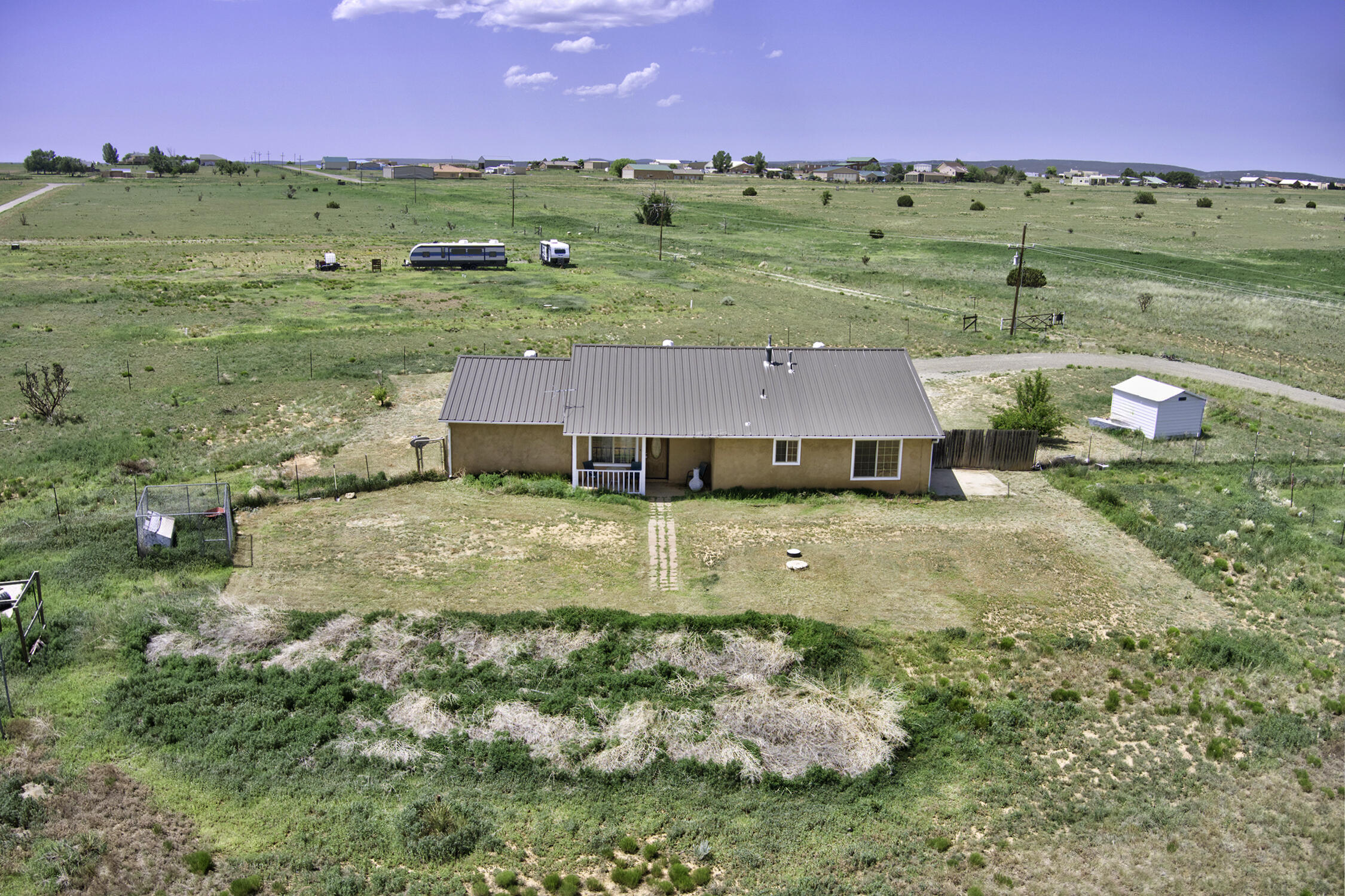 Don't miss this Rare Opportunity, deeded access to Sandia Airpark Estates Airport. This 1590 Square foot home sites on 2.75 fully fenced acres with 360 degree views. Inside the home you will find a wide open floor plan with a cathedral ceiling and lots of natural light. The Great room includes the living Room, dining area  and the kitchen with tiled counter tops, ample cabinets, a 5 burner gas range, dishwasher, built in microwave, and a breakfast bar. The primary bedroom has a large en suite with large walk in shower. The heated 2 car garage has built in storage area and is partially divided for a workshop, hobby room or possible 4th bedroom. Recent updates include Metal Roof in 2018, HVAC system and Water Softener in the summer of 2020, Fresh paint, carpet and garbage disposal May 2025