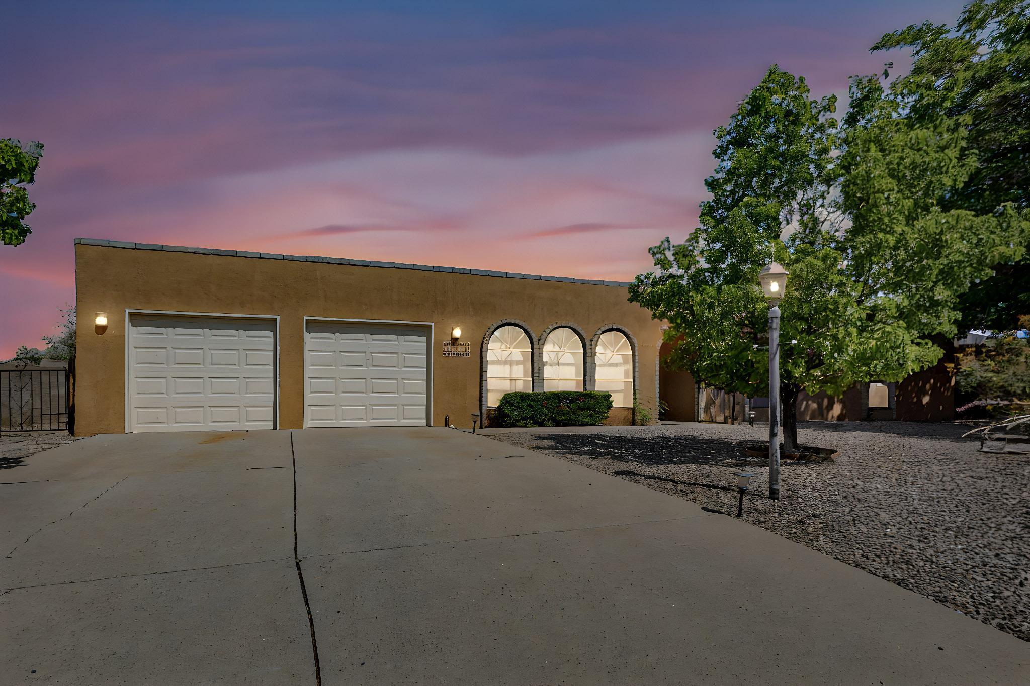 Pueblo-style charmer in Paradise Hills desirable  golf course community with stunning Sandia Mountain views from the front! The spacious great room features a cozy kiva fireplace and opens to a well-designed kitchen with abundant counter and cabinet space plus a huge pantry. Formal dining/living area offers flexibility for entertaining. Generously sized bedrooms and separate office provide comfort and privacy. Enjoy outdoor living on the large covered patio overlooking a terraced 1/3-acre lot with backyard access, RV parking, and a storage shed. A perfect blend of Southwestern style, space, and functionality!