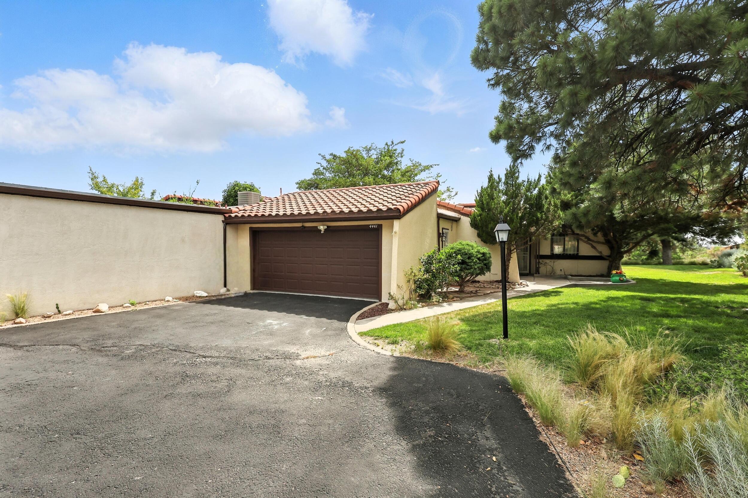Tucked beside a lush HOA green space where deer love to visit, this inviting townhome blends charm and function. Skylights and three sliding doors fill the home with natural light while two cozy wood-burning fireplaces add warmth and character, including one in the primary suite for an extra touch of comfort. The kitchen offers solid surface counters and stainless steel appliances. Bathrooms are finished in sleek cultured marble with thoughtful details throughout, including a relaxing jetted tub. The finished garage is a true bonus with epoxy floors, a built-in workbench, and abundant storage. Outside, the open patio invites morning coffee or evening unwinding, surrounded by well-kept greenery and soft grass that enhance the curb appeal.