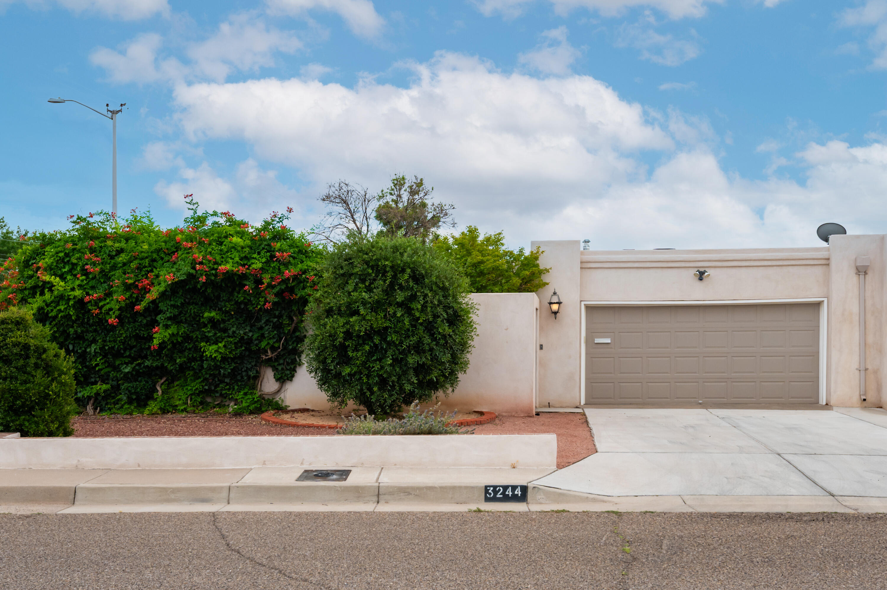Gated courtyard entrance with lush landscaped private patio area greet you as you enter this Mossman built townhome. Raised ceilings, multiple skylights & solar tubes for tons of natural light. Spacious kitchen with tile floors, white painted cabinets and neutral counter tops. Great wrap around floorplan with nice flow-large family dining room off of the kitchen with updated light fixture and beautiful laminate wood floors that extend through the Great room. Wood burning fireplace is the center of the room, vwet bar or coffee bar, wood burning fireplace and built-in shelves. Heated sunroom-updated windows & overlooks the charming backyard.  2 spacious bedrooms w/ updated bathrooms! Sweet yard w/ patio and lovely landscape. Oversized 2 car garage w/ storage & security iron on entire home.