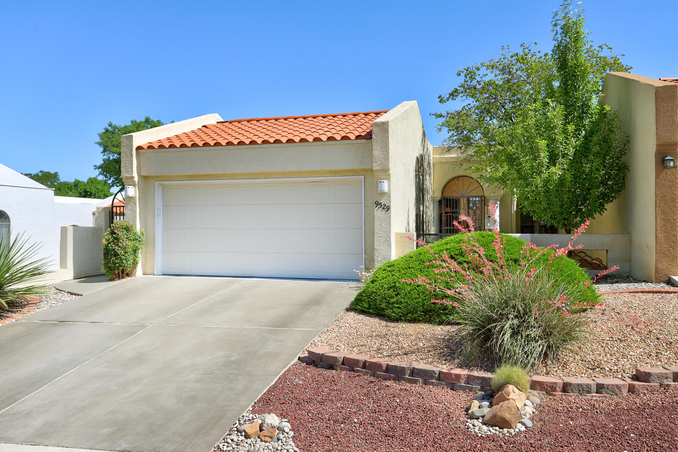 Welcome to this delightful HOME in the Heritage East community! Offering a gated front courtyard + security doors, & bars all around the home for peace of mind. A spacious great room w soaring ceilings & cozy fireplace--perfect for relaxing or entertaining. Kitchen boasts beautiful granite counters & breakfast nook, making every meal a joy. Enjoy ultimate privacy w 2 bedrooms located on opposite sides of the home. Oversized primary suite includes a luxurious bath + expansive 8.9' x 7' walk-in closet! Office room is convenient off great room & primary suite w large walk-in storage closet--ideal for working from home or a hobby space. Outside is an oasis w lush grass, flowers, fruit trees, & VIEWS of Mts & Tram. Sipping your morning coffee or hosting a gathering, this backyard is perfect!