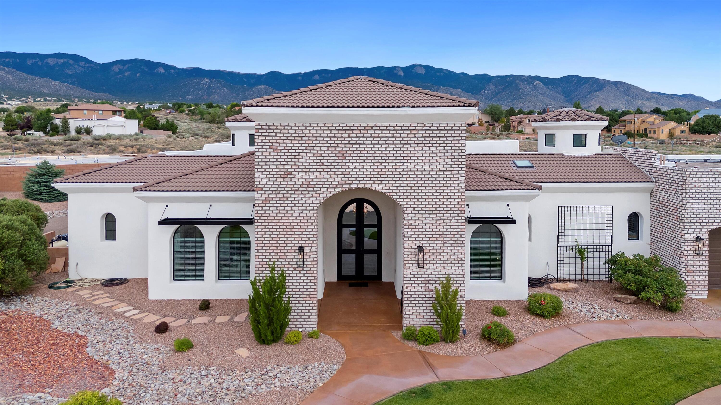 Experience resort-style living in the heart of North Albuquerque! This extraordinary custom home is a true oasis, offering a rare blend of elegance, comfort, and unforgettable views. With 4 to 5 bedrooms, 4 bathrooms, and a flowing open-concept design, this residence is built to impress.Step outside and be transported to your own private paradise. The lush, mature landscaping surrounds the property with vibrant greenery, producing fruit trees, and manicured grass lawns in both the front and backyards. The color-cured concrete walkways and patios add a refined touch to the outdoor aesthetic.At the heart of the backyard retreat is a custom-designed pool with a built-in hot tub, dramatic rock waterfall, and thrilling slide--perfect for relaxing or entertaining in style.