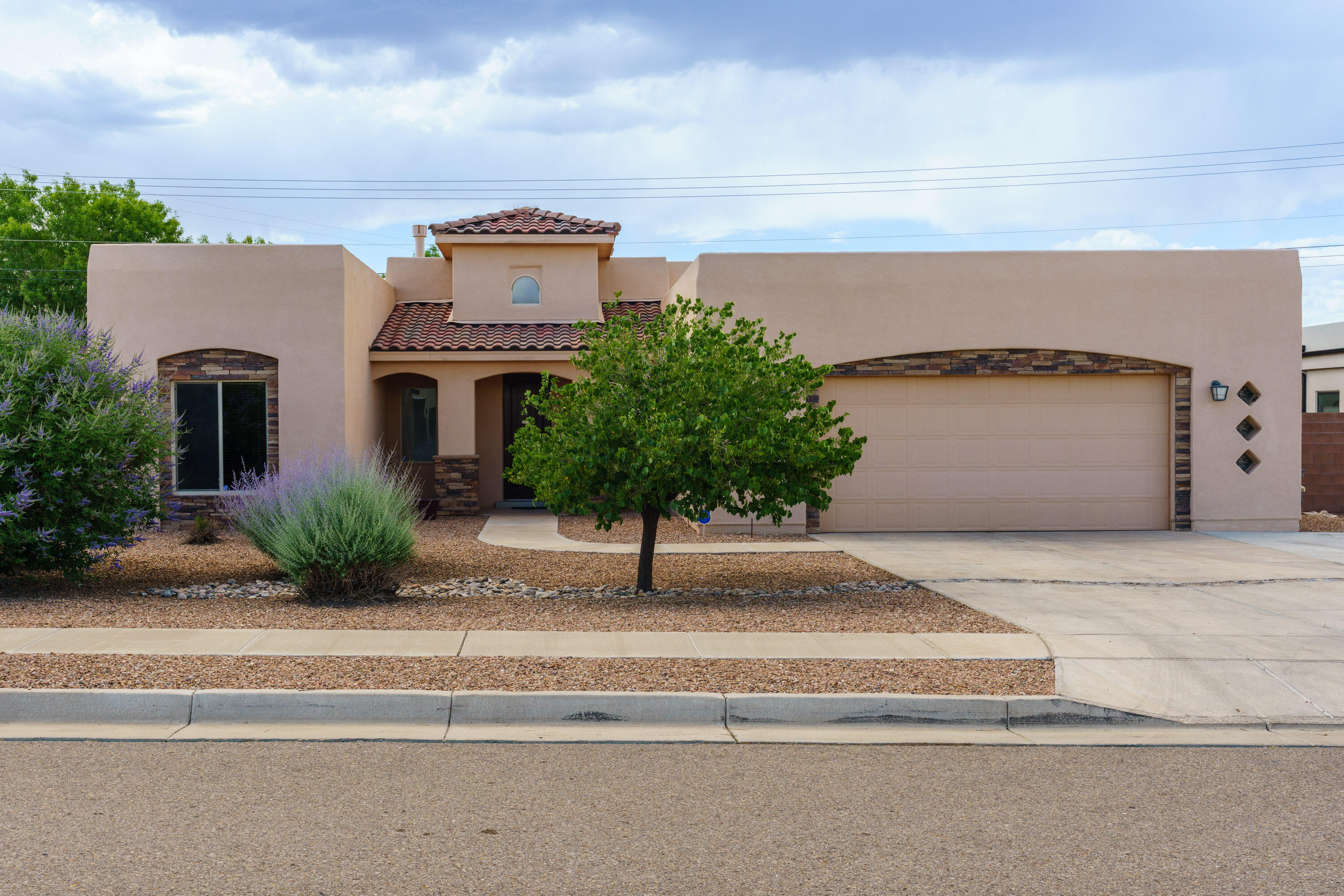 With one of the most well-thought-out layouts, this home blends privacy, comfort and smart design. Located in the desirable Volcano Cliffs neighborhood surrounded by custom homes, this Casa Verde-built beauty offers a timeless style with an NM Green Build Gold status for efficiency. Each of the three bedrooms is thoughtfully placed in separate wings, creating privacy and flow. The spacious kitchen features a generous pantry, oversized island, and french doors leading to a covered patio and a xeriscaped, low-maintenance backyard. The luxurious primary suite includes a spa-like bath and an a spacious walk-in closet that leads directly into the laundry room. The oversized two-car garage features a mudroom, storage and has the potential for tandem three-car use- a workshop dream.