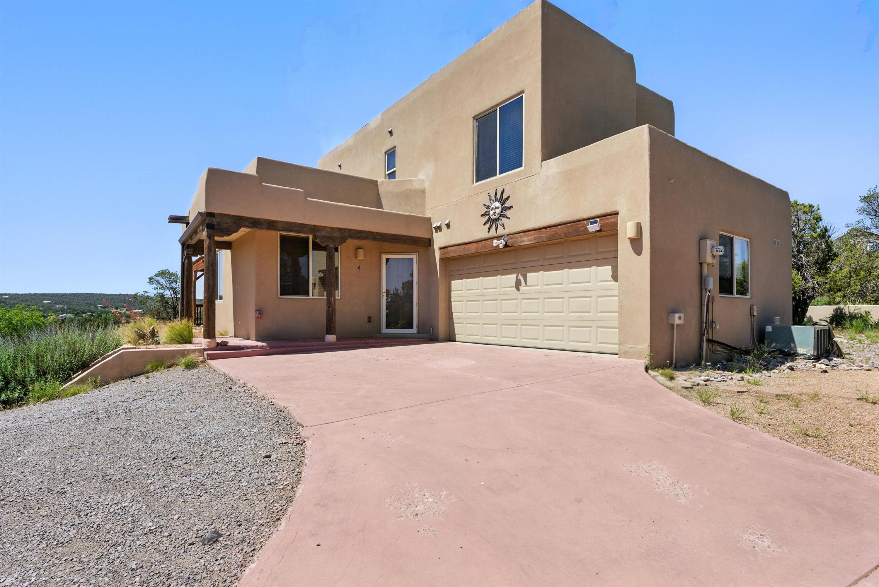 Bright and happy two-story custom home in the East Mountains has so much to offer! Located at the end of a cul-de-sac, the property's exterior features include a private gated entry, a concrete driveway, a deck with breathtaking views of the mountains and meadows. Interior features include a gas log fireplace, exposed beam vigas, tile flooring and countertops. The windows are situated for stunning panorama and let in tons of natural light. The three bedrooms are located on the second level. The primary bedroom features a private balcony. The primary bath has a large garden tub and separate shower. The HOA maintains the roads and does snow removal. Homeowners and their guests have exclusive access to hiking trails and open space areas.