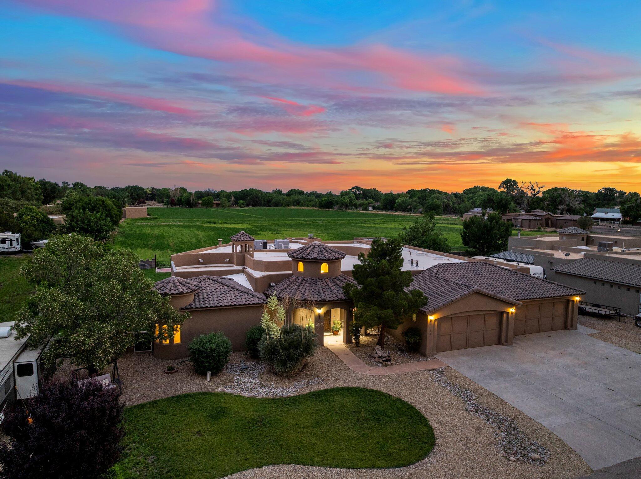 2 irrigated acres, a 6-car garage, dedicated movie room, horse stable, and all within a private gated community surrounded by other luxury estates! As you pull into the property, you'll immediately notice the RV parking, ample driveway space, and the added privacy of no home directly in front of you. Step inside through the grand foyer, where a dramatic rotunda with soaring ceilings and abundant natural light welcomes you into the heart of the home. The thoughtfully designed open-concept floor plan flows seamlessly to an oversized living room, complete with custom built-ins, a cozy fireplace, and French doors leading to an expansive covered patio, designed for year-round entertaining. At the center of the home, the show-stopping chef's kitchen is equipped with level 4 granite countertops,