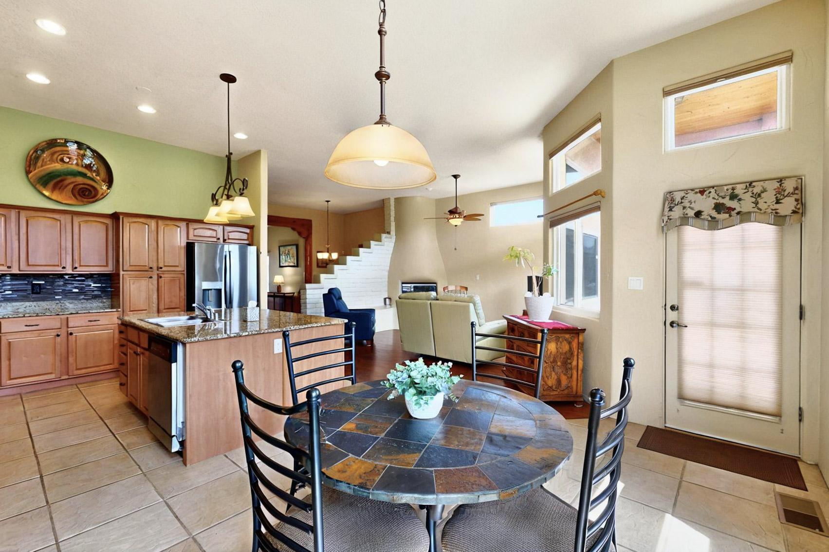 Lovingly kept & updated 1-story home in the desirable Petroglyph Shadows neighborhood. This 4-bedroom, 2.5-bath home sits on a spacious corner lot, in a pocket neighborhood boasting an open floor plan, updated Renewal by Anderson windows, owned solar panels-$11.79 monthly PNM bill, refrigerated air & a whole house water filtration system, blending Southwest charm with modern living. Enjoy hand scraped engineered wood floors, updated light fixtures and architectural details like vigas and corbels in the living and dining rooms, an adobe accent wall separating the two living areas, and a cozy kiva-style gas log fireplace in the family room. Clerestory windows bring in abundant natural light. The kitchen is both stylish and functional, offering granite countertops, a decorative tiled