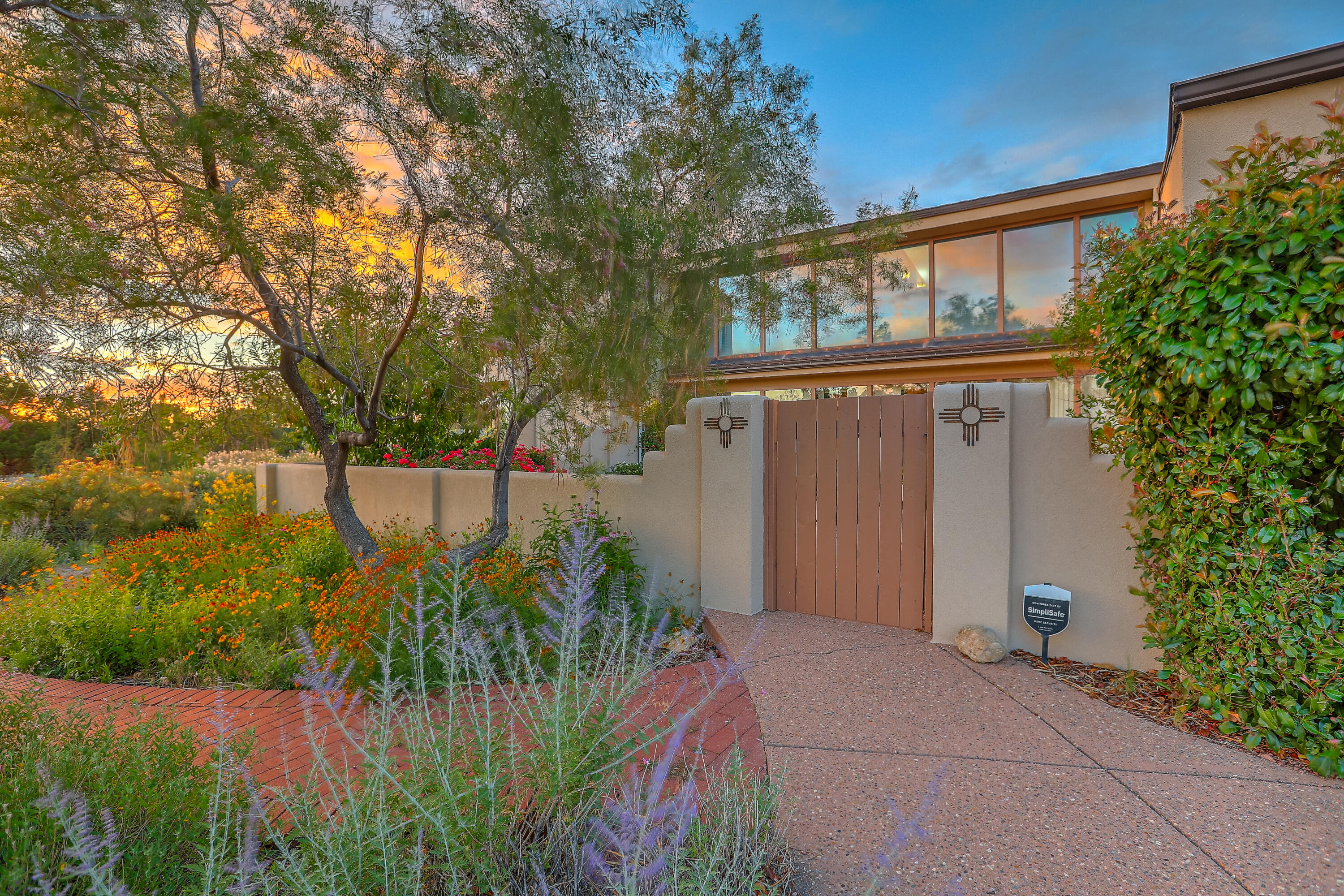 Wake up to breathtaking views in this beautifully designed home that captures the magic of the Sandias. Perfectly positioned to maximize views, this property also features sustainable living at its best--with passive solar Trombe wall heating and a tankless water heater. The main floor includes two bedrooms, a full bath, and warm brick flooring that grounds the space in natural charm. Upstairs, the spacious primary suite and office offer stunning elevated views you'll never tire of. Enjoy the oversized garage and a lush, productive backyard with strawberries, raspberries, grapes, and seven dwarf fruit trees--cherry, nectarines, 2 pears, and 3 apples. Entertain or unwind in the outdoor kitchen while soaking in the mountain views. This is New Mexico living at its finest.