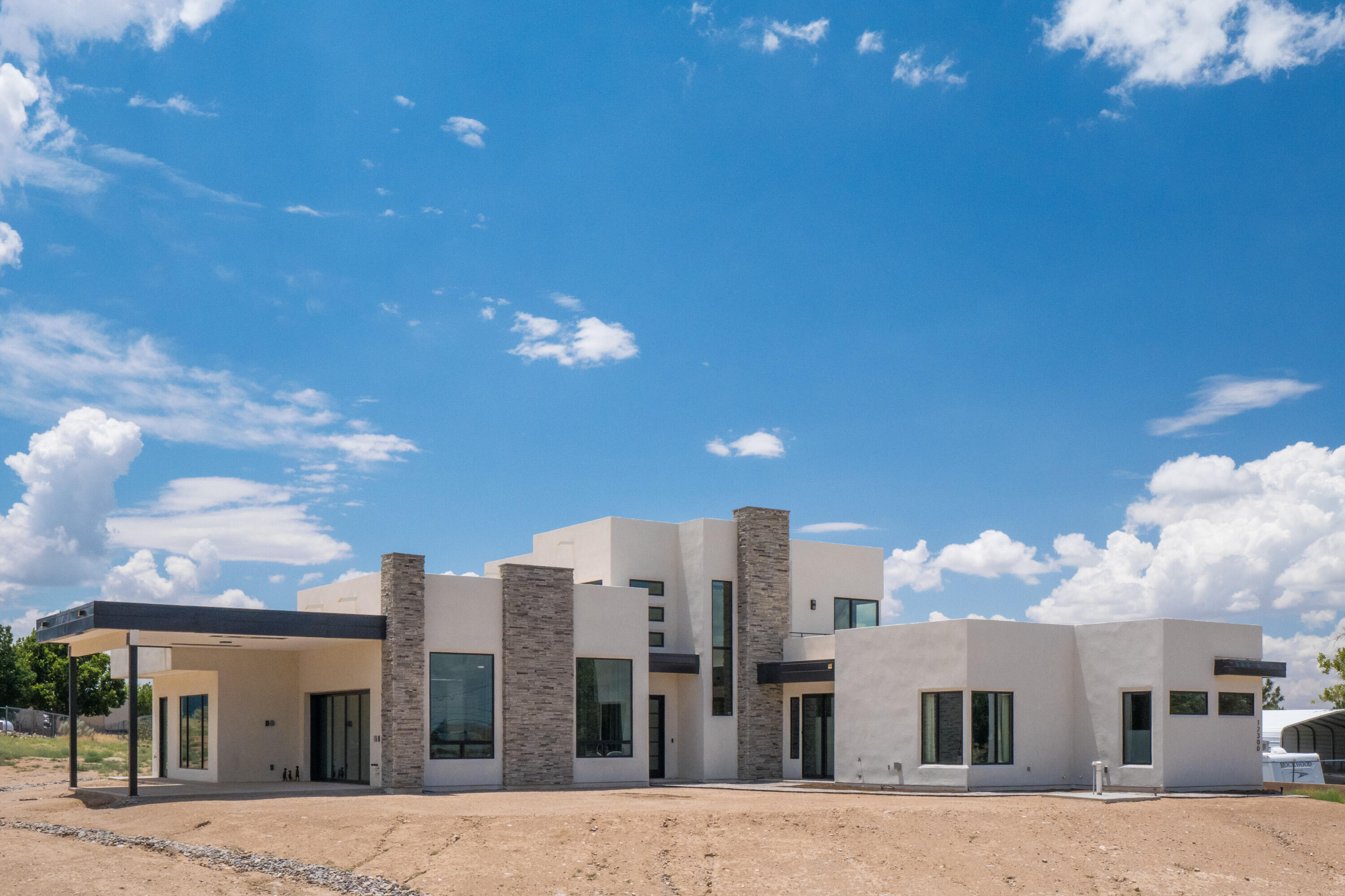 Experience the best of New Mexico living in this thoughtfully designed custom home featuring breathtaking, unobstructed views of the Sandia Mountains. Built with comfort, efficiency, and entertainment in mind, this New Mexico Certified Green Build offers high-end fixtures and appliances, a multi-zone refrigerated air system, and a versatile layout perfect for multi-generational living. Welcome guests into the attached casita wing--complete with 2 bedrooms and its own entrance. ADA compliant. Main living area opens effortlessly to the outdoors with a glass vanishing wall that leads to a spacious, covered patio ideal for entertaining. Currently minimal, the yard offers a blank canvas ready for your dream landscaping design - a tranquil desert oasis, vibrant garden, or sleek modern courtyard.