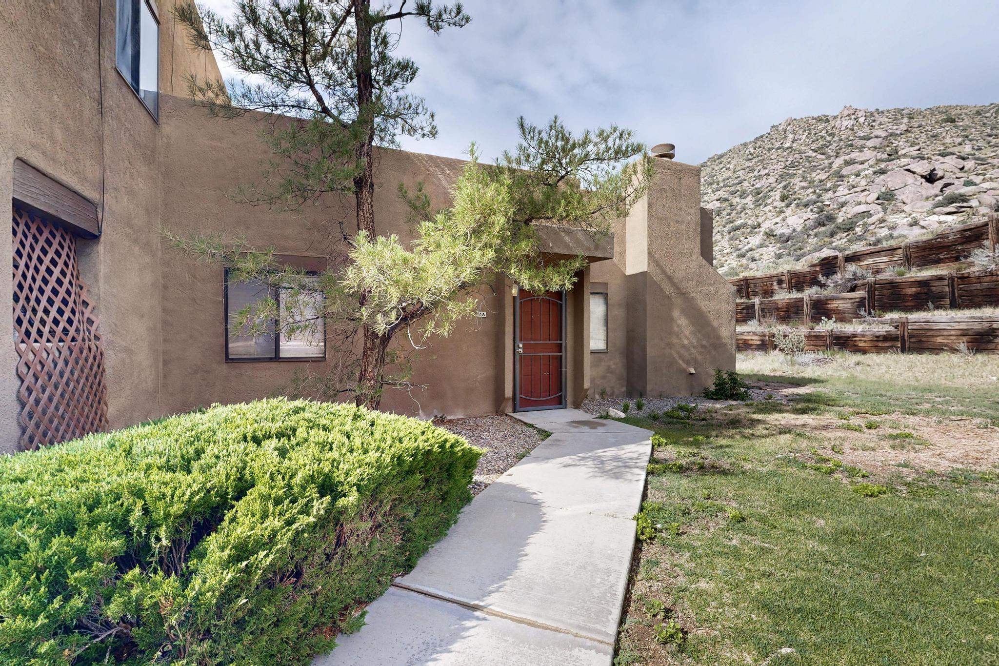 Nestled at the base of the majestic Sandia Mountains and backing directly to open space, this beautifully updated condo offers the perfect blend of comfort, convenience, and natural beauty. Step inside to an oversized living room filled with abundant natural light and anchored by a charming wood-burning fireplace, a cozy focal point for relaxing or entertaining.Enjoy peaceful mornings or serene sunsets from your private, fenced-in back porch with views of the foothills. Situated in one of the most sought-after areas of the Foothills, this home places you just moments from scenic hiking and biking trails, yet remains close to city conveniences.