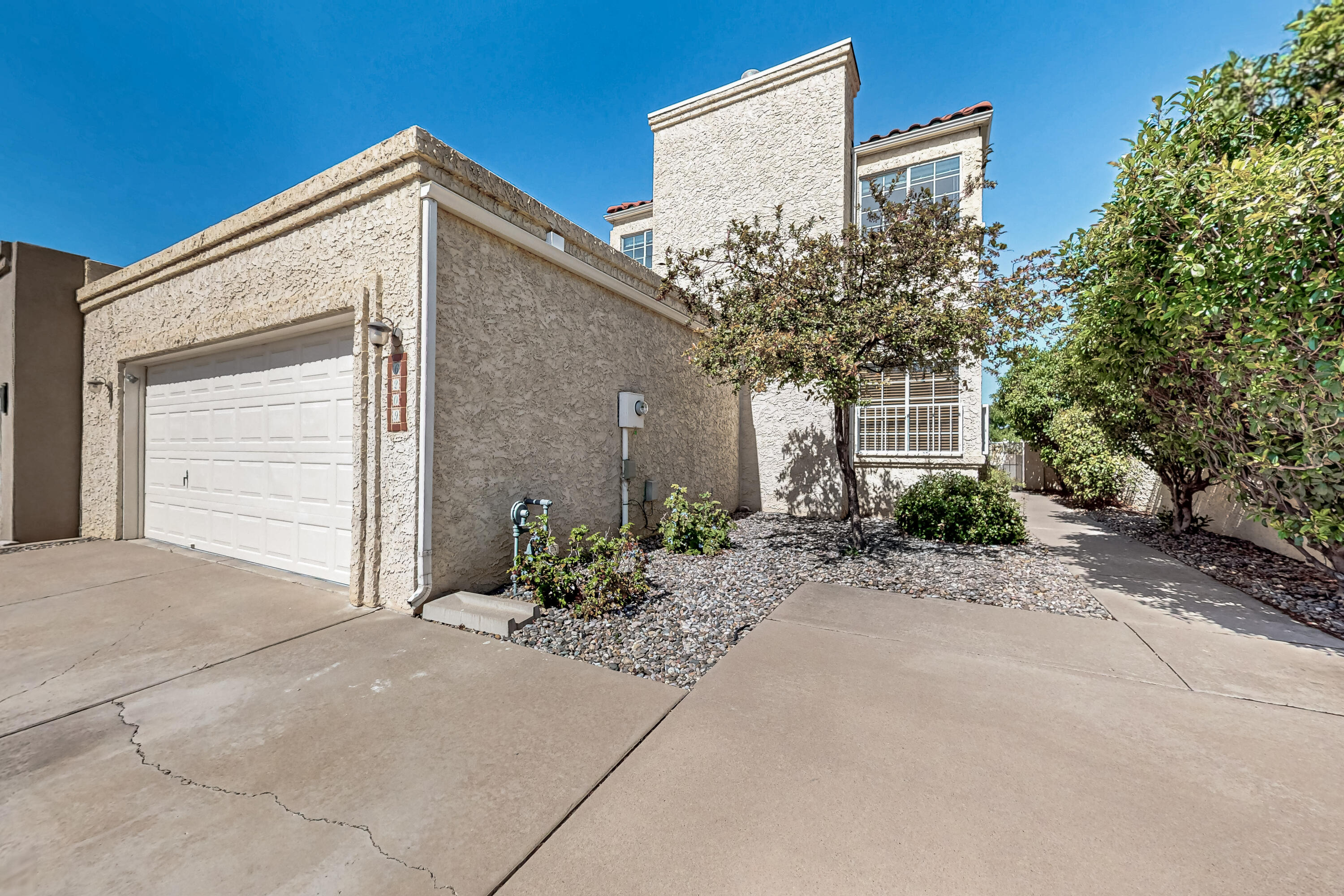 One owner custom built townhouse in convenient location with City & Mountain Views! Welcome guests with two living areas, wood burning fireplace, downstairs half bathroom and access to grassy backyard with covered patio. Eat-in kitchen with granite counters, island and lots of cabinet space opens to private side courtyard. Primary upstairs bedroom includes a west facing balcony with city views and an updated ensuite with custom tile shower, separate tub, double sinks and walk-in closet. Two other bedrooms with Sandia Mountain views, loft desk, full hall bathroom and laundry room complete the upstairs. Oversized garage with storage and Refrigerated A/C!