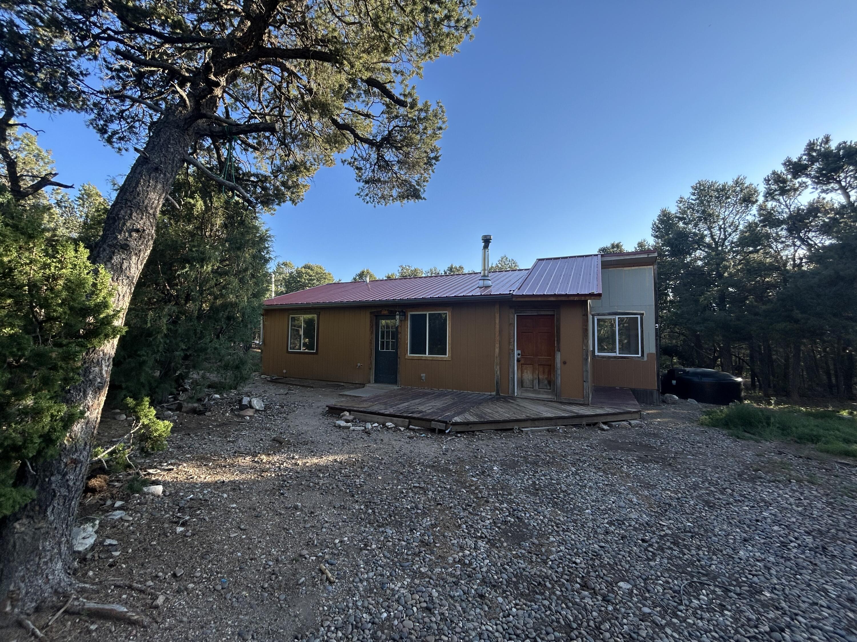 Welcome to Holiday Hills in the East Mountains.   1 bedroom  ( could be 2 bedroom) with 1 full bathroom.  Kitchen with dinning room or 2nd living room.  Located on just under an acre... This lot is treed , Paved road to Richard ...