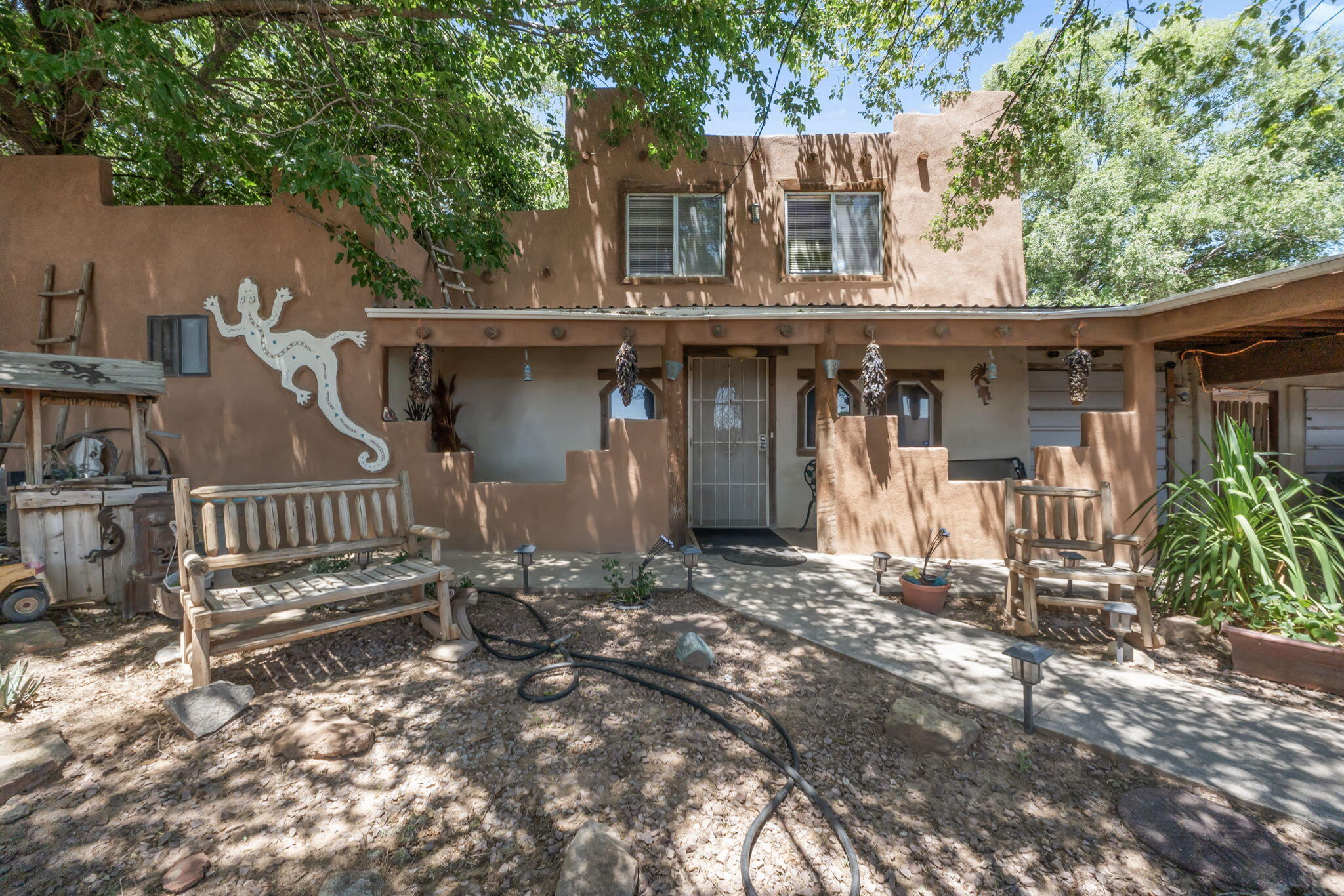 This historic, 100 + yr old home offers a blend of classic NM charm and practical functionality. Upon entry, you're greeted by a warm Kiva fireplace, perfect for chilly NM winters. As you enter further, you'll find the ample-sized kitchen, highlighted by a large walk-in pantry, ideal for storage and everyday use. Adjacent to the home is a separate space with its own entrance, ideal for storage or possible living space.  The property also includes a gated back with backyard access and parking to accommodate multiple vehicles or equipment. One of the standout features is the large workshop outfitted with 220V power, offering excellent potential for projects or hobbies that require a large space. Buyer to verify sqft if that's important to them. special financing may also be available!