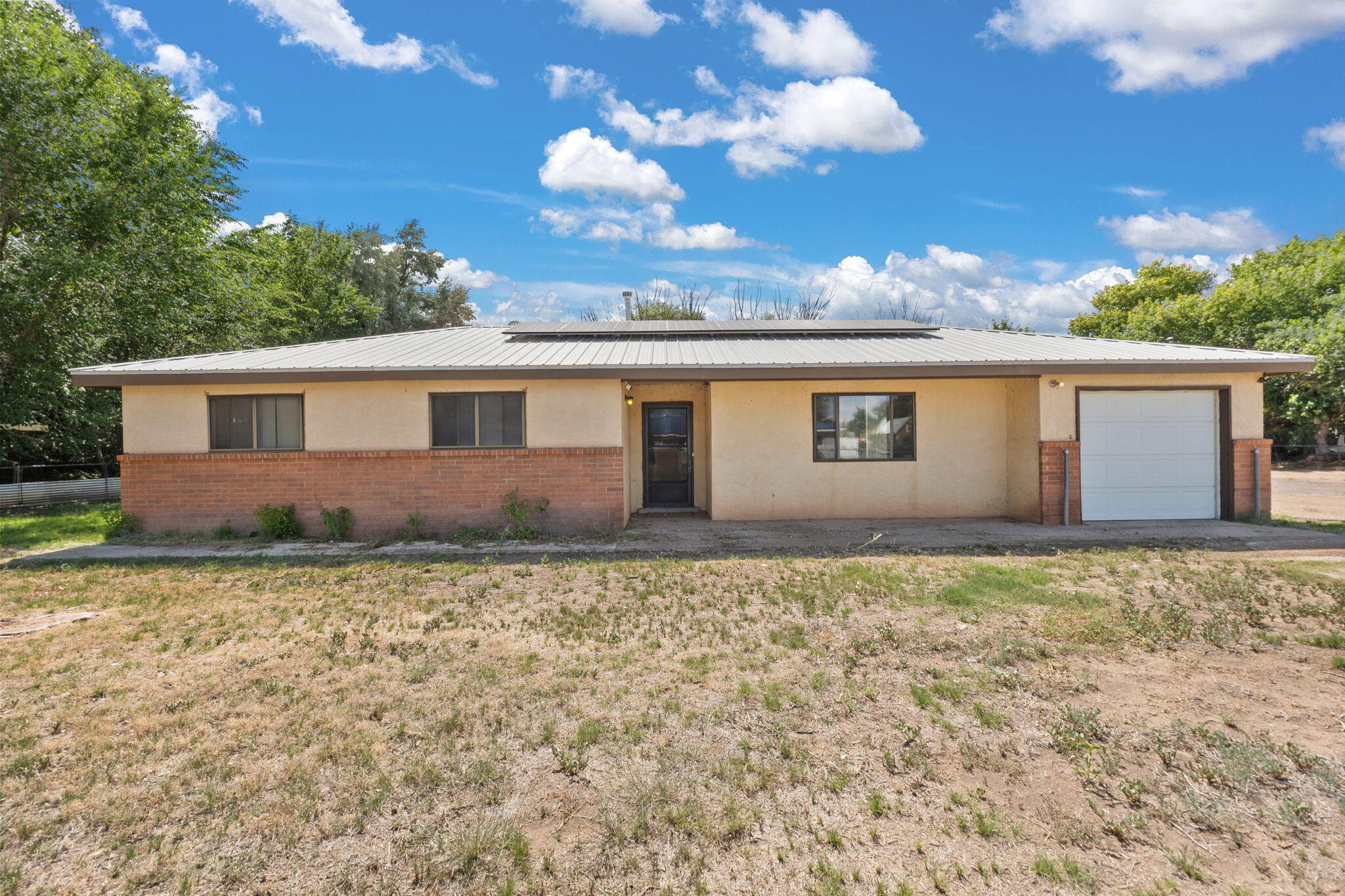 Discover comfort and character in this inviting single-story ranch in the heart of Los Lunas. Boasting 1,593 sq ft, 3 bedrooms and 2 full baths, this 1972-built home has been thoughtfully updated with newer tile, carpet, and fresh paint that accentuate its classic features. The original kitchen lends itself to culinary creativity or full-scale remodeling, while the bright living area provides plenty of room for relaxing or entertaining. Enjoy modern comfort with central heating and air and solar energy. Outside, the fenced .44-acre backyard and 1-car garage offer space and convenience for family gatherings and outdoor fun. Located in a friendly, well-kept neighborhood and zoned for quality schools, this home is perfect for family!