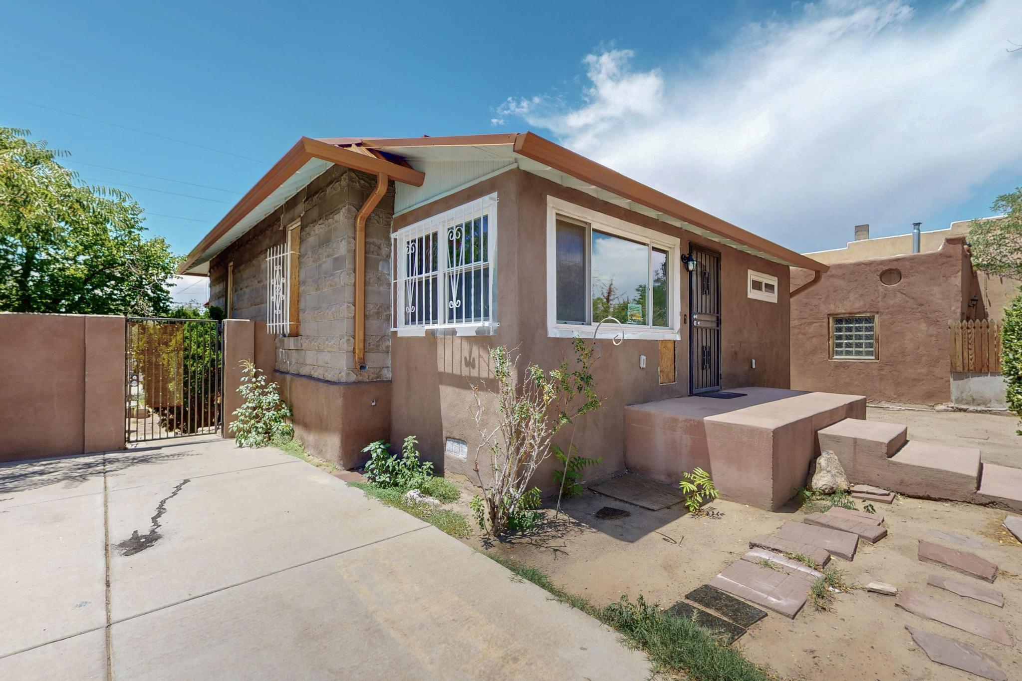 Investor special with enormous potential in established neighborhood! Nice sized lot includes a main house and casita waiting for your creativity! Main house updates include Metal roof (approx. 2014), bath/showers (2014), stucco (2016), kitchen countertop & primary bath vanity (2025) some windows/paint (2025); Casita T&G roof (2016), some paint (2025); electrical on property updated 2025. Main house features a kitchen on both floors, open living space, primary walk in closet, ample storage, spacious deck. Casita features wood beam ceilings and a cozy layout. Off street gated parking in front and back, 3 storage sheds, close to I-25, downtown, UNM/UNM sports complex, Presbyterian, airport. Seize this rare opportunity to own and improve a unique property by seeing it today! Sold ''as is''.