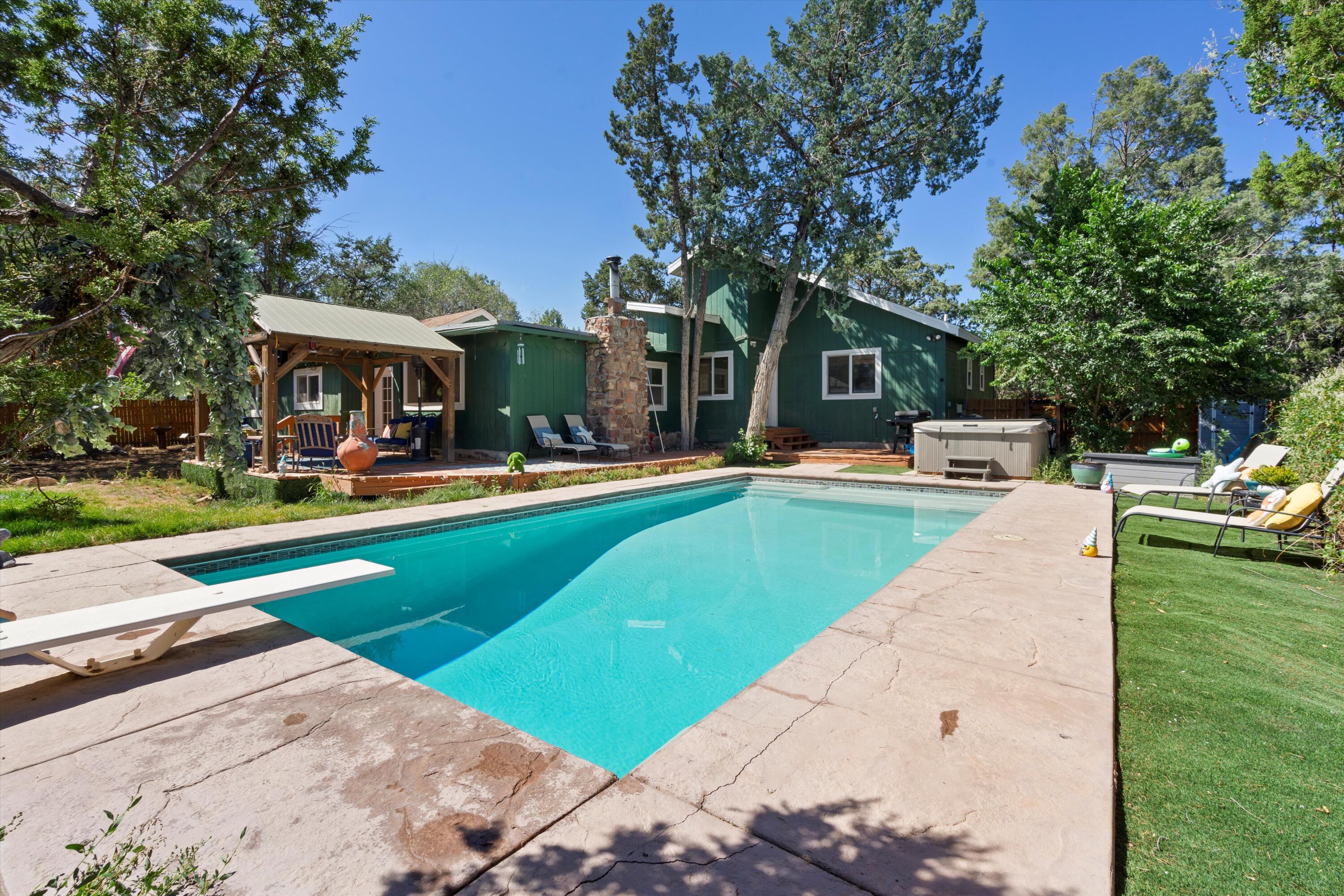 Calling all outdoor enthusiasts!! Live close to the National Forest and Sandia Crest...within minutes from the ski area and the mountain trails to explore. Charming single level home boasting 4 spacious bedrooms, 3 baths, open country kitchen with modern stainless appliances. Oversized primary bedroom provides a serene retreat. Enjoy the luxury of the heated gunite pool! Experience the perfect blend of mountain serenity and modern convenience in this wonderful home!