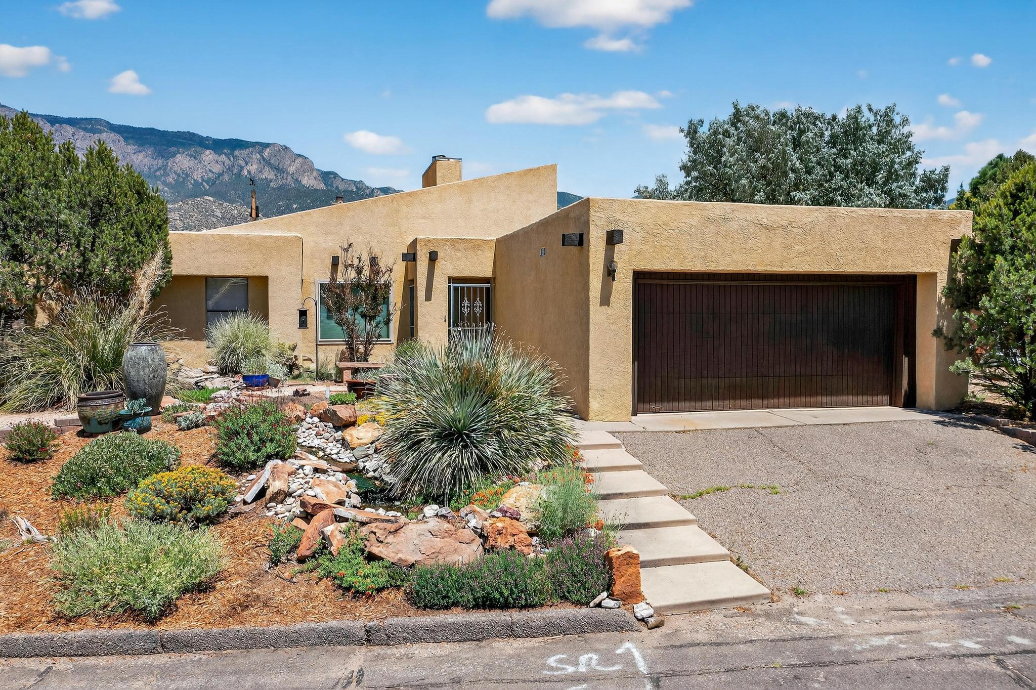 A SMART BUY! You are going to love this beautifully updated Sandia Heights patio home full of tasteful upgrades and timeless charm! This light-filled home features a large living room with soaring beamed ceilings and a cozy two-way fireplace, a luxurious primary suite, and a dining room with a huge picture window and abundant natural light. Recent updates include a newer TPO roof, HVAC system, dual-pane windows, countertops, fresh paint throughout, and brand-new carpet. The home is professionally xeriscaped front and back, with a tranquil fountain and stream creating a peaceful outdoor retreat. Other features include built in bookshelves and display case, a sunroom (not in sqft), covered patio, and easy access to hiking and biking in the beautiful Sandia foothills. WELCOME HOME!!!