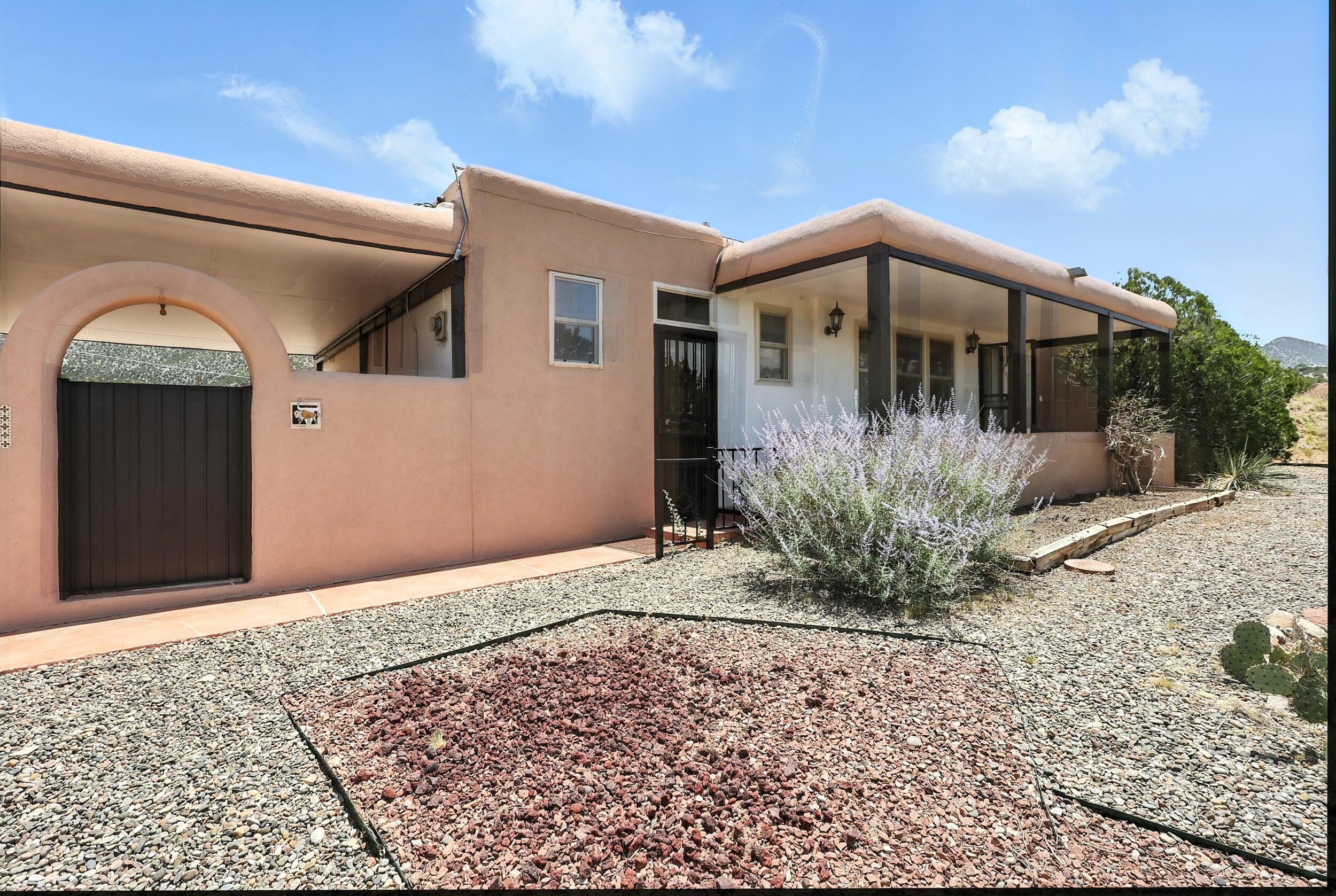 STUNNING VIEWS - 3 BR ON 4 ACRES! $435,000. Affordable hilltop home with panoramic views. 1544 sq ft adobe with exposed beams and wood ceilings! 3 Bedrooms, 2 Baths, plus 2 car garage with extra storage, 335 sq ft breezeway, and 2 covered porches. Beautiful, brand new wood (engineered hardwood), plus tile floors; no carpet! Comfortable floor plan with 2 living areas, eat-in kitchen. Excellent Sandia views, as well as views to the north! No covenants, so animals are allowed (horses, goats, chickens, pets, etc). The 4 acres is already platted as 2 lots and there is a great place to build another home up the hill south of the house! New well drilled in 2021, new septic in 2012, newer roof, furnace and cooler too. Easy access: just 1/2 mile from Highway 165, not far from National Forest!