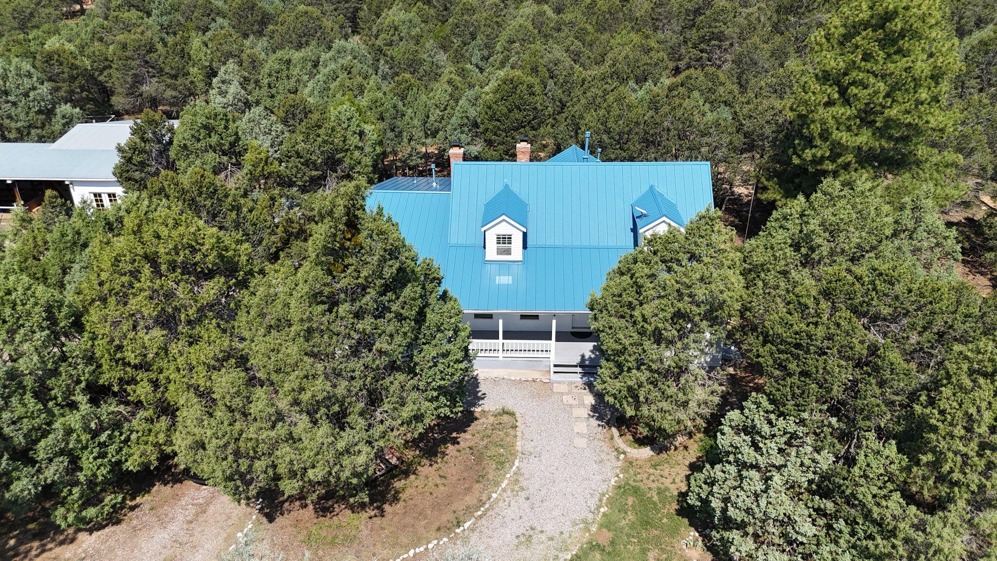 Escape to your private Mountain oasis on 9+ac! This 3000+/- Sq. Ft. home offers rustic charm with modern convenience, with 4 beds, 3 baths, two living spaces, and an office. A towering ponderosa-lined driveway leads you home and into nature's serenity, with two fireplaces for cold winter days! Step outside where a 3-stall pole barn and a 3-car garage are ready for your animals and toys. Metal roof installed 10/24. Just 30 min from the city with lots of room to roam, this East Mountain Gem won't last long!