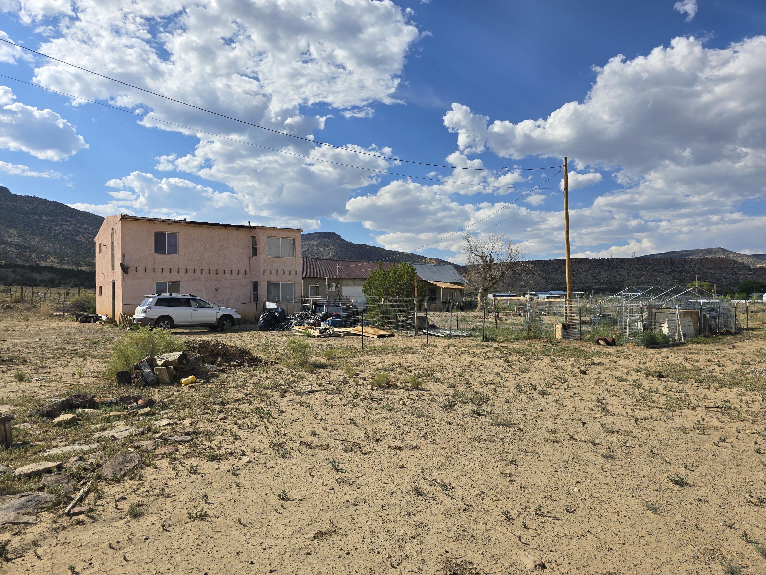 Captivating 3-bed, 2-bath home with attached 1-bed and 1-bath guest/studio apartment on 3.25 acres in scenic Bibo, New Mexico. Perfect for extended family or rental income. While the home needs some work, it is fully livable, with solid bones and endless potential for the right buyer. The entire property is fenced, making it ideal for livestock. There's also access to irrigation, a crucial asset for anyone dreaming of starting a garden, orchard, or small-scale agricultural operation. Combined with solar panels and community water, this property offers self-sufficiency and sustainability rarely found at this price point.