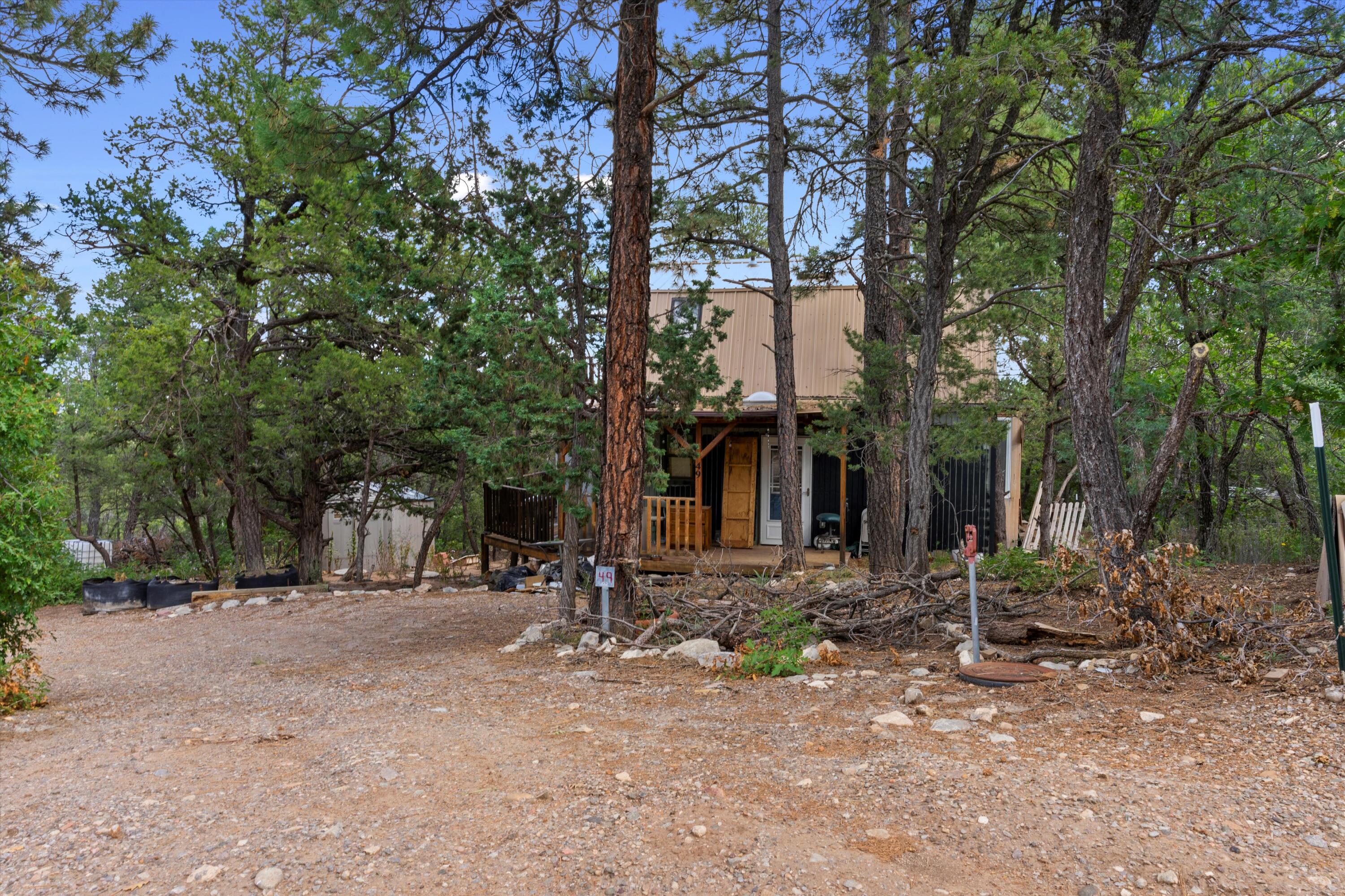 Welcome to this tranquil 1 acre property nestled among the majestic ponderosa pines. This charming cabin combines the serene beauty of nature with the cozy comfort of a 2-story retreat with its inviting porch that wraps around the house. 2 bedrooms with the opportunity to grow. This 1026 square foot cabin offers a peaceful sanctuary in a picturesque setting. The living area is a cozy space, perfect for relaxation or gathering. Large windows allow natural light to filter in, creating a bright and inviting ambiance. The one-acre property allows ample space to create outdoor living areas or gardens. Please Use Caution when entering to the back bonus room off the living room as it doesn't have foundation. Must see in person to experience it. TLC is needed and the right person will love it.