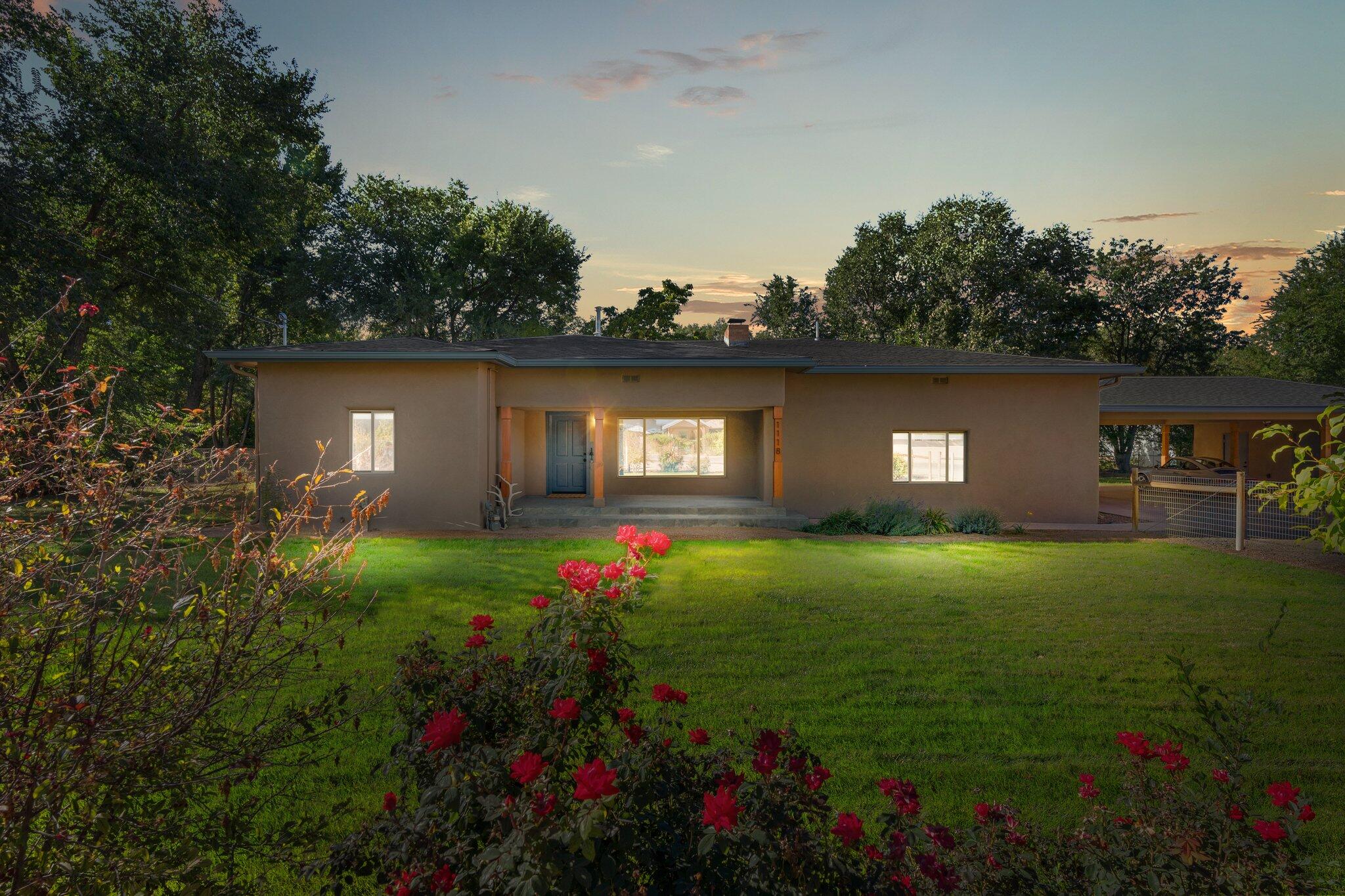 Beautiful remodeled adobe home located in the heart of Los Ranchos, bordering the Pueblo Acequia system, on a large 1.03 acre property! This charming farmhouse features 2,282sf with 3 bedrooms, 2.5 bathrooms and 2 living areas. New roof in 2022! Upgraded plank flooring flows throughout this open floor plan. Great living area with a wood burning fireplace. Fully remodeled kitchen with custom cabinetry, engineered stone countertops, subway tiled backsplash and upgraded stainless steel appliances. Spacious owners suite with dual sinks, a large walk-in shower and closet! pastures on both sides of the house can be flood irrigated via the acequia or with the well. Pastures offer the opportunity to farm, garden or add live stock!  Automatic gate and carport!