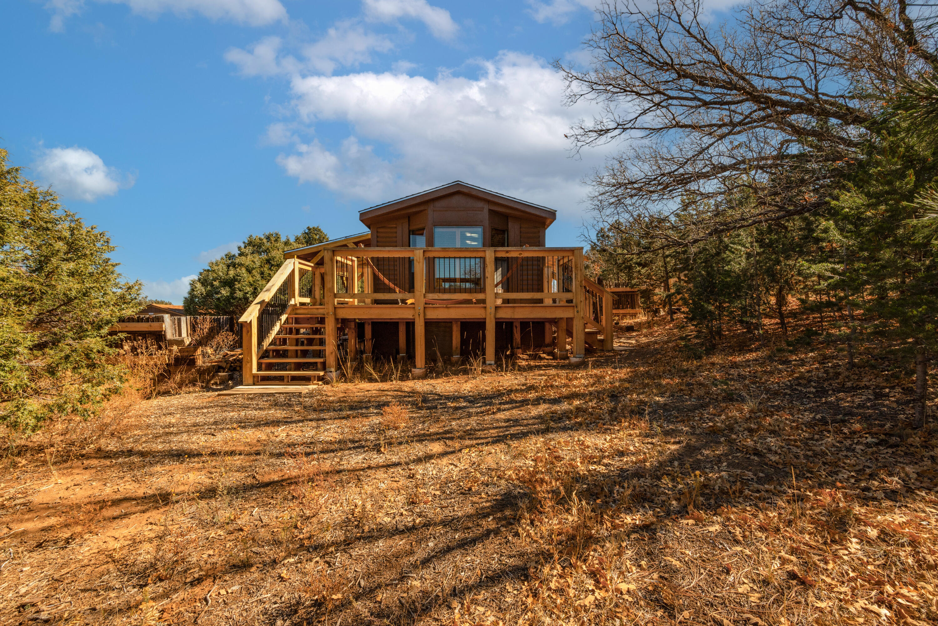 Look what just hit the market!! Peace and quiet abound in this mountain cabin retreat nestled among the pinon, oak and ponderosa pines in Ramblewood Estates subdivision. Estate sacrificing this charming log cabin-sided singlewide on an acre of land. Shared well and septic system, outdoor living spaces including portals front and back as well as relaxing/meditation deck. Listen to the winds whispering through the trees. Inside relax in the cozy cabin decor complete with wood burning stove to take the chill off the late fall and winter air. Three storage sheds strategically scattered around outside of home. Come fall in love. Easy commute to Tijeras, Edgewood and Albuquerque.