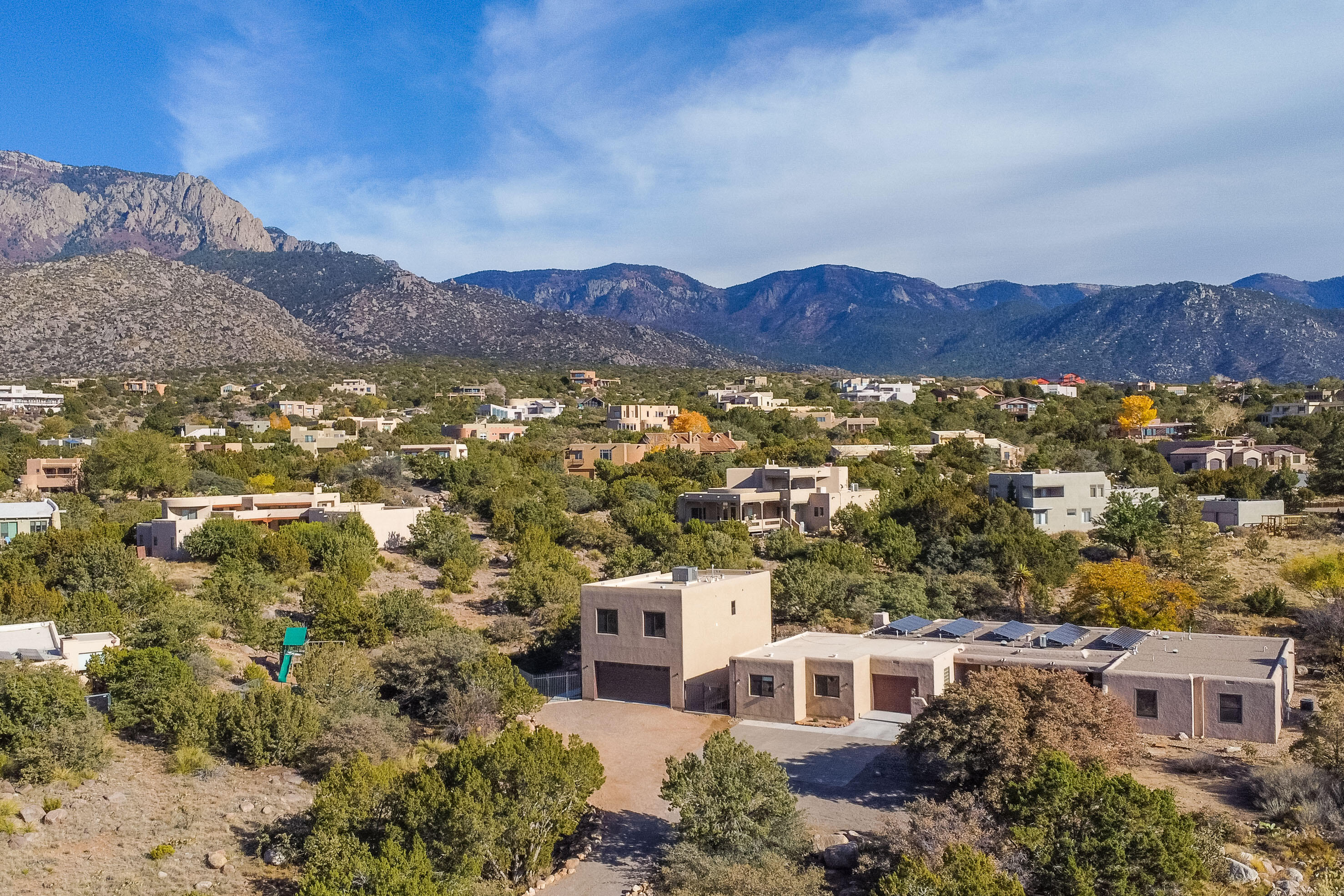 Open House: Sunday 4/28 (1-3 pm). Extensively updated home in Sandia Heights on large 1.2 acre lot. One story home with 4 bedrooms, 2 1/2 baths & attached 3 car garage with built-in 28-drawer workbench. Brand new heated 2-car garage with area for workshop & amazing upper-level artist studio with stunning views. Inviting courtyard entry with custom metal gate. Updated kitchen with custom wood cabinets, granite countertops, stainless steel appliances, & water softening system (includes a reverse osmosis sys). Unique glass doors to the pantry & laundry room. Washer/dryer combo unit. Unique mosaic tile design in dining room & living room. Recently refinished Red Oak hardwood floors throughout. Private backyard with large, covered patio, fruit trees & raised vegetable planter.
