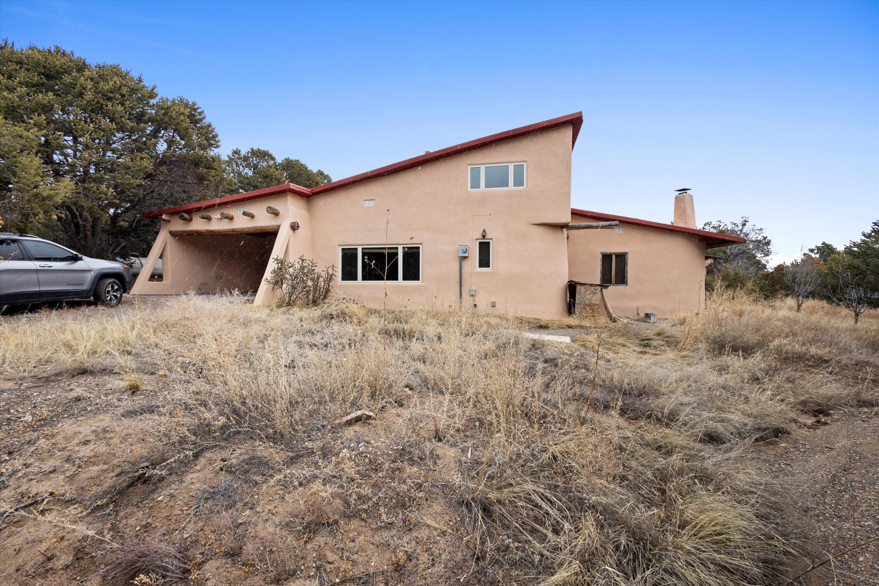 Calling All Investors and Creative Buyers! This Fixer Upper is a Unique and Special multi level Adobe with a warm and homey atmosphere. 2.5 Acres! You can easily fall in love with the Santa Fe style Viga and Latillas touches. Sunken Living Room with Kiva fireplace is grand. 2 Freestanding Pellet Stoves and Wood Burning Stove keeps it cozy all winter long. Plenty of room for the entire family and guest/teen quarters and 2 Lofts for Office or Workout Gym Space. Horses are welcome. Fenced Wooded and Meadowed lot with plenty of room to roam.