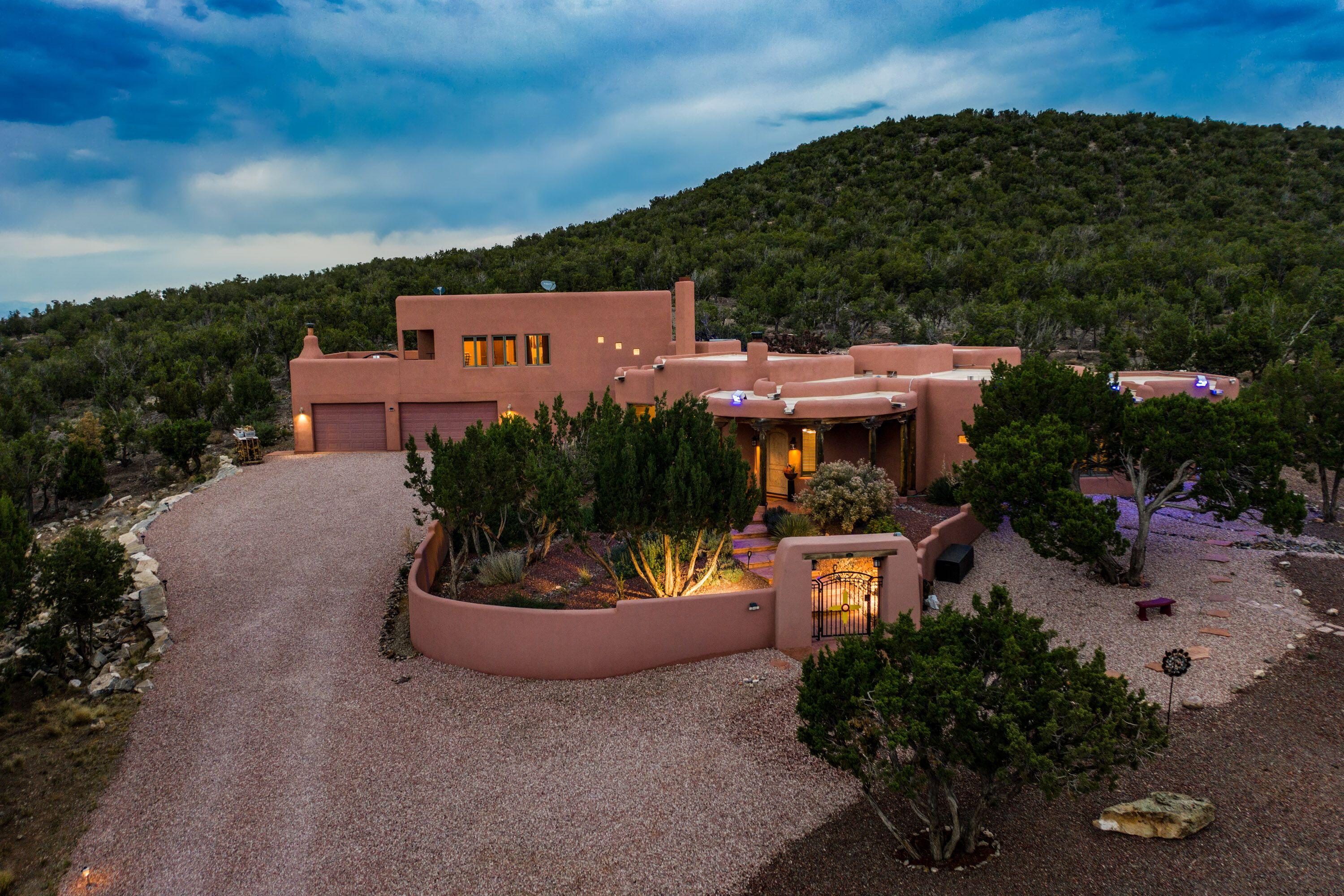 Take a breath! You finally have escaped the hustle and bustle of the city. Now enjoy the fresh mountain air of 28 Canon Escondido with unobstructed views of National Forest. This extraordinary home offers the epitome of intimate New Mexican architecture with hand-crafted finishes: kiva fireplaces, vigas, clay plaster walls, beautiful hardwood and Mexican Saltillo tile flooring. Hand-chiseled doors, fabulous and artful light fixtures, & more. The warm finishes are combined with superior insulated concrete form construction and heated with in-floor radiant plus two central HVAC units. Located conveniently between Albuquerque and Santa Fe, this distinguished and desirable community allows access within 30 minutes to the city and 45 to Santa Fe. Canon Escondido is tucked away in a hidden cany