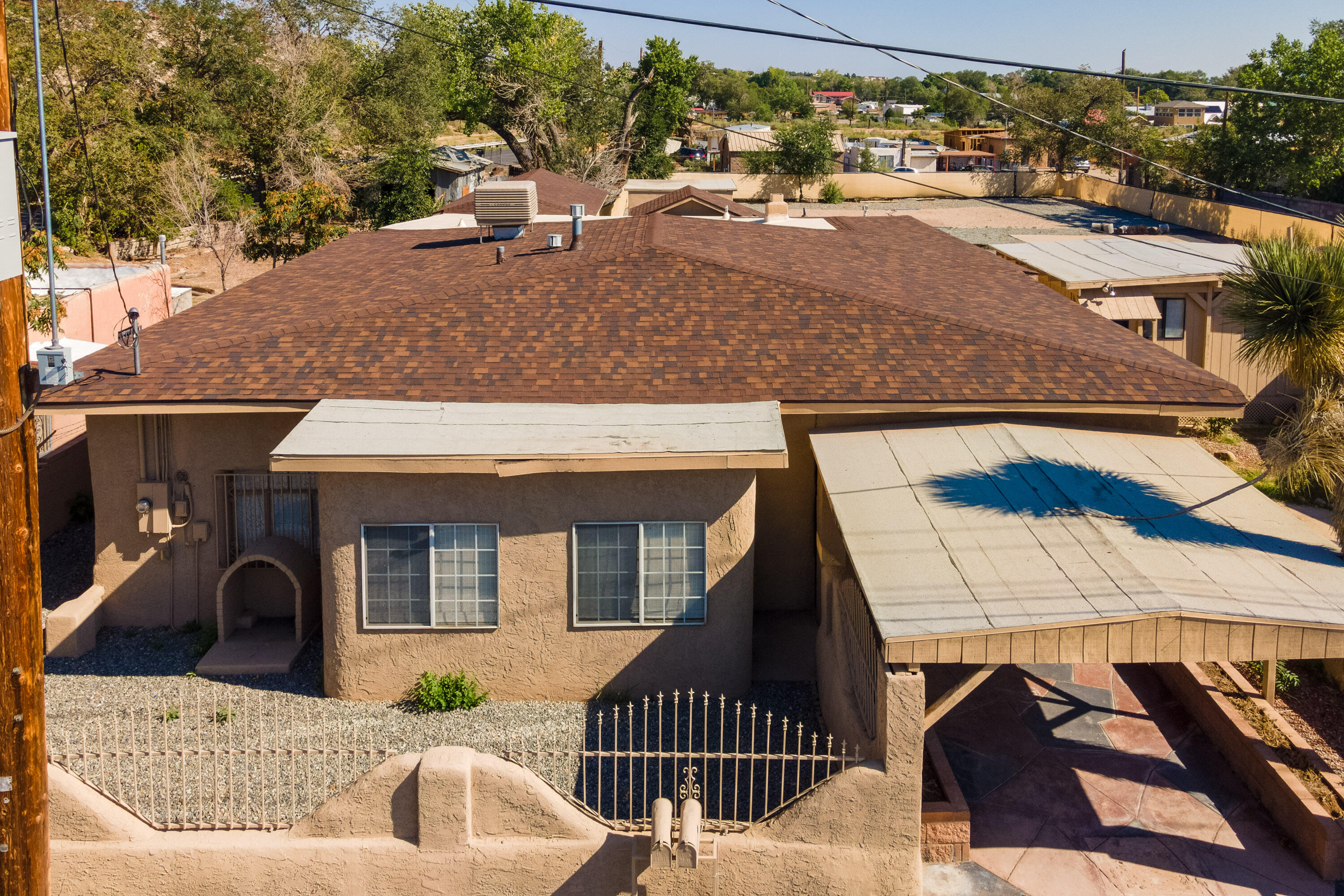 NEW ROOF NEW PRICE.  This is a remarkable renovation on a turn of the century Southwest Adobe compound, NEW ROOFING INSTALLED  ON BOTH HOUSES SEPTEMBER 2024 It includes a main house, a completely renovated guest house, a studio, a garden office, and a humble shed. Granite counter tops, stainless steel appliances, new fixtures, marble floors in the bathrooms, upgraded HVAC, new mini-splits, new electrical, upgraded plumbing, all in 2023, complete this mindful renovation.  All accessory buildings are heated and air conditioned.  This half acre lot includes a volleyball court, with room for RV parking, gardens or grow an orchard with MRGCD water.