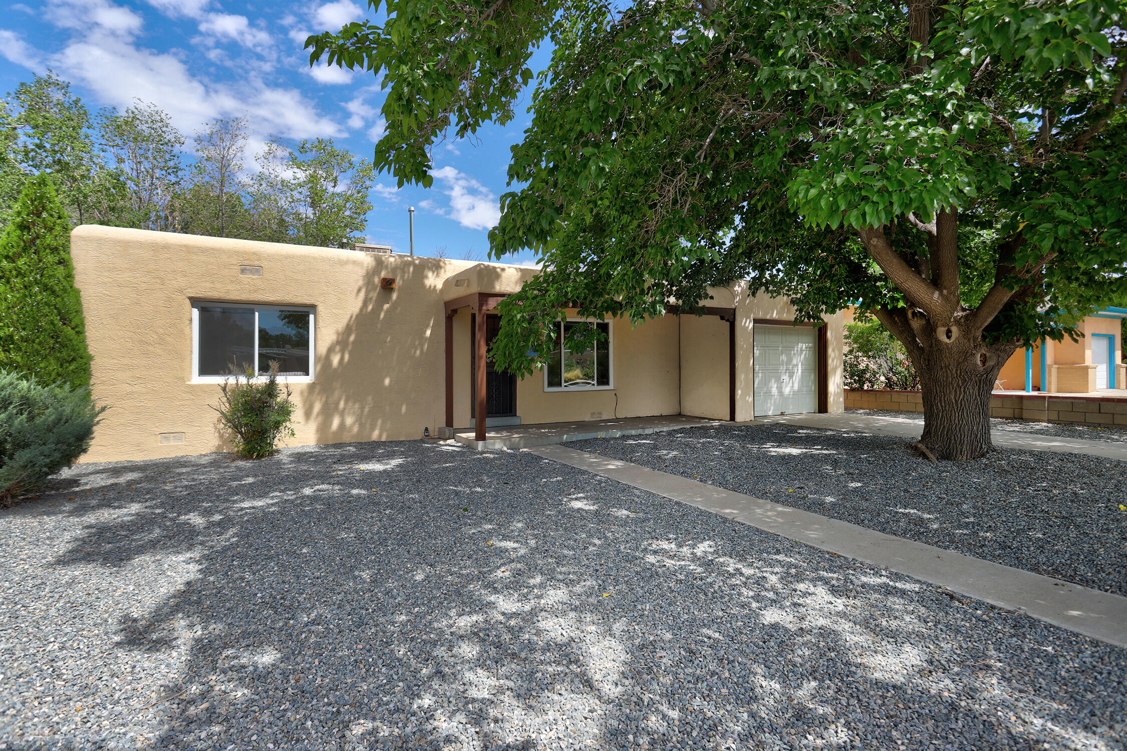 What an adorable bungalow with wood & tile floors.  Nice sized bedrooms, cute living room with hardwood floors and fireplace.  The large den has a cozy stone, wood burning fireplace and some built in book shelves. Large windows look out to a huge back yard just waiting for your vision of serenity to make memories in.  Front yard is easy care landscape, The one car garage is a nice size too.  This home has a really nice floor plan and great bones. Furnace,  water heater and roof were all replaced approx. in 2017. Evaporative cooler was replaced this July of 2024.  BRAND NEW VINYL WINDOWS installed in front living room, primary bedroom, 2nd bedroom, & guest bath in mid August 2024.