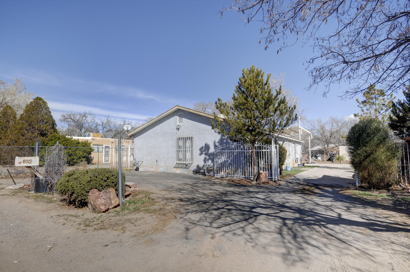 Back on market! Previous buyer did not qualify. Introducing a charming 2 bed, 2 bath home nestled in a darling neighborhood. This property offers privacy with a secure gate and a spacious carport. Featuring a durable metal roof, elegant French doors, and exquisite hardwood flooring throughout.  Meticulously cherished and maintained with numerous updates, it boasts unique details that add to its appeal. The beautiful lighting and shelving enhance the inviting atmosphere, while the kitchen boasts lovely countertops. The open living and kitchen space creates a seamless flow for entertaining. Situated on a generously sized lot, enjoy the vibrant blooms during the spring and summer seasons. Don't miss out on this gem of a home that combines comfort, style, and tranquility.