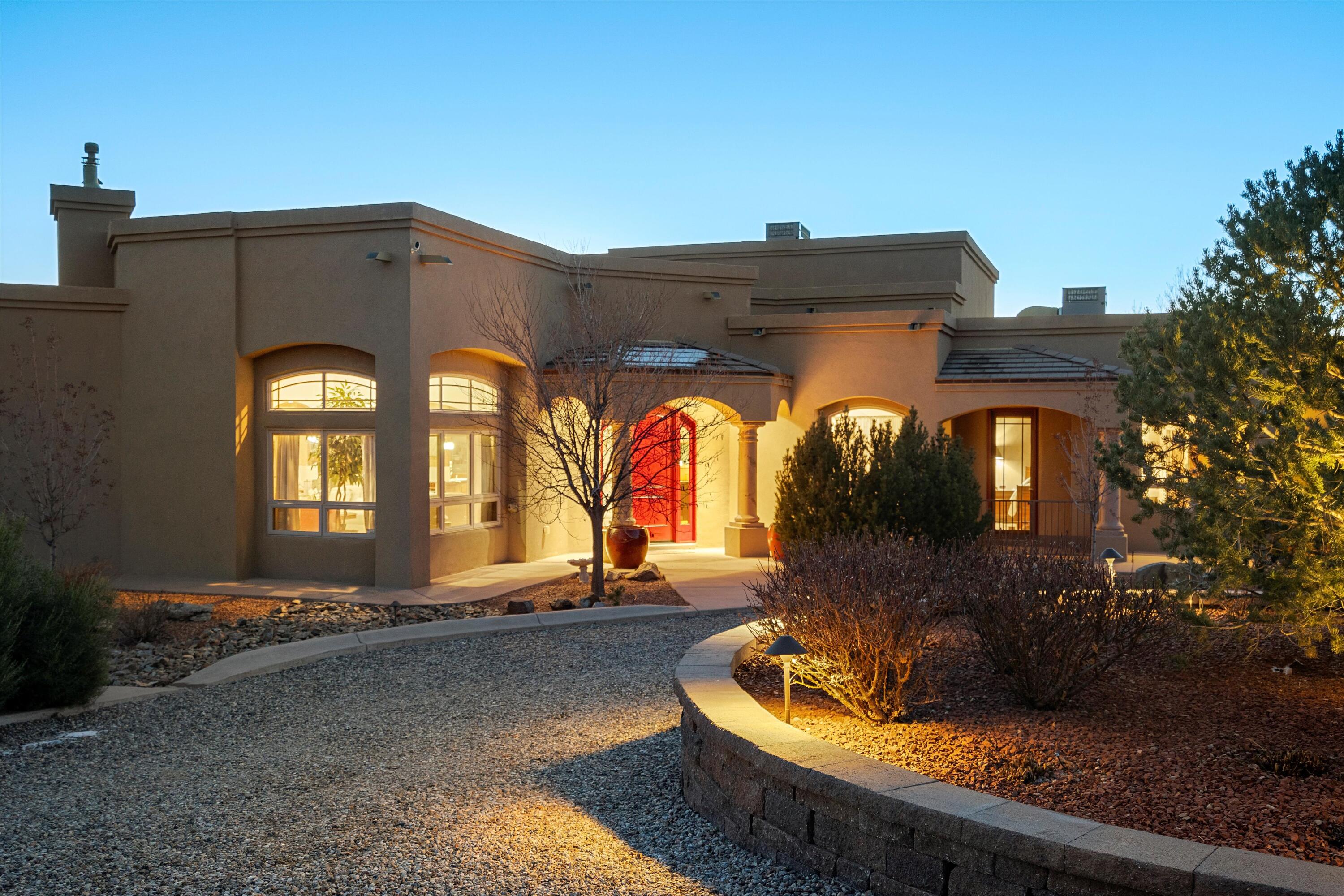 This gorgeous home in North Albuquerque Acres is a combination of elegant design and detail, gracefully arranged to provide superior comfort. This home is nestled in a beautifully landscaped and privately gated .89 acre lot. You will get to enjoy features like  beautiful VIEWS from its covered balconies and large private patios. A cozy retreat area featuring a heated endless pool next to a beautiful kiva fireplace awaits you. This practical and versatile floorplan offers over 4700 sqft of living area, which includes a detached guest house of almost 1,000 sqft. Detached building also houses a large RV garage and tons of storage space. There is an amazing large greenhouse where you can plant year round. All of this is powered by owned solar panels. Come and see for yourself!