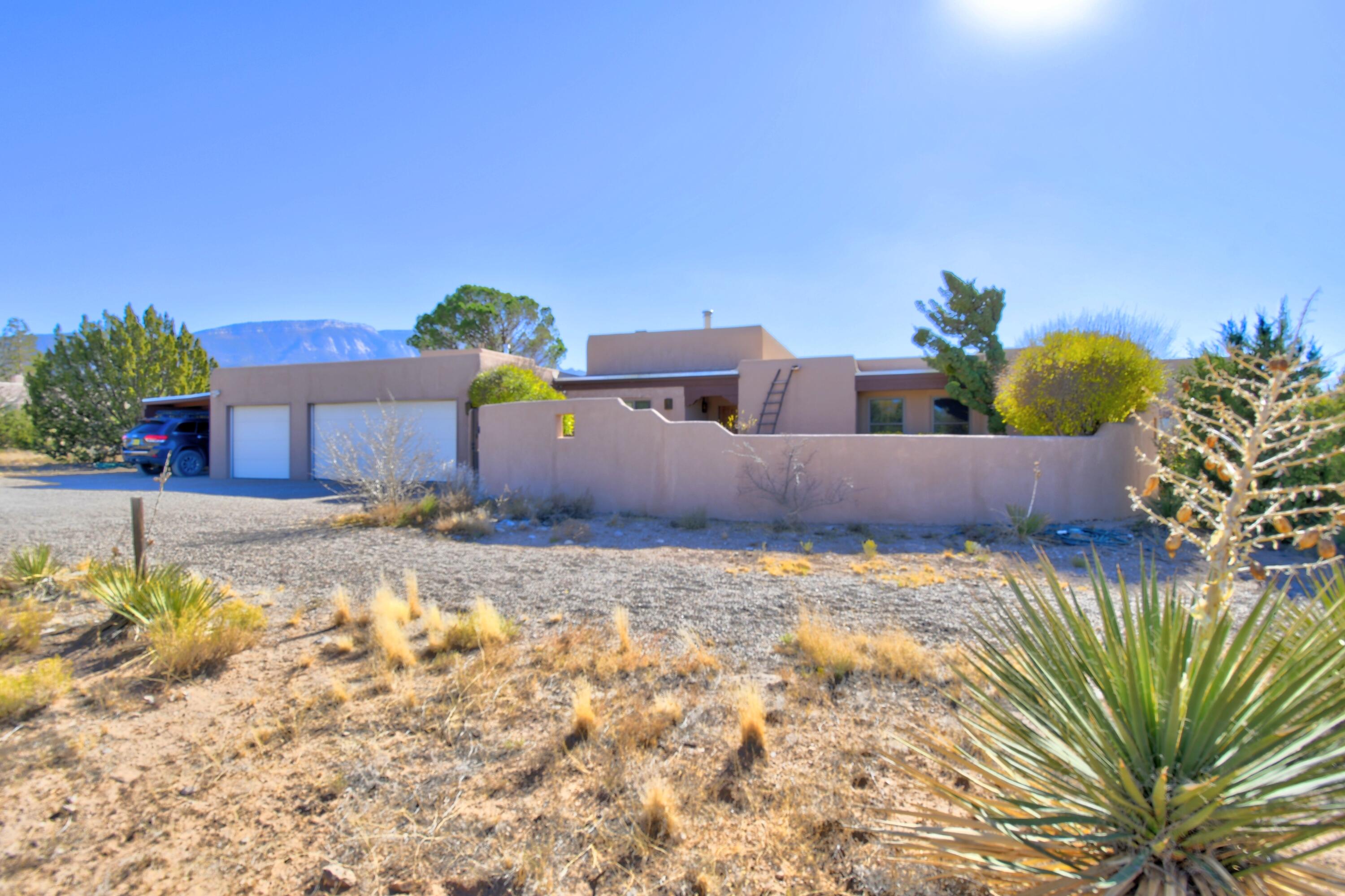 Welcome to this custom 1-level home (sunken living room does have 2 steps) on a 2.3 acre lot with amazing views of the Sandia Mountains, city lights & northern mesa views! Relax in the back yard and enjoy starry nights. Minutes to I-25 for easy access. T&G beamed ceilings, brick floors in kitchen, dining & living rooms. Kiva fireplace in living and a wood stove in the entry area. Refrigerated A/C in 2021. New well & pump 2019 - shared with available vacant lot next door. Studio/rec room is an addition with interior and exterior entrance - split unit for heating/cooling. Wood clad windows replaced 2019. Office could be a 4th bedroom. New septic 2021. 3 car garage + a carport. Silicone roof 2019 - has a transferable warranty until 2029.