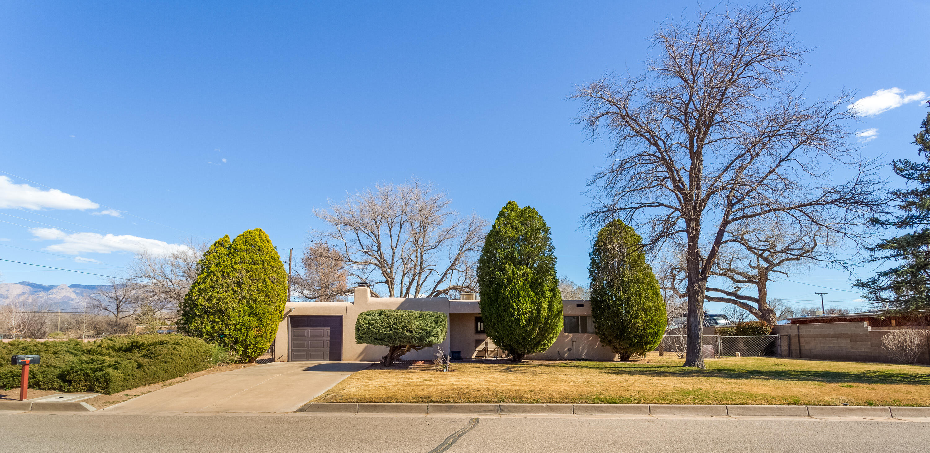 This home presents a rare opportunity to live in the heart of Albuquerque's verdant North Valley. It has been lovingly maintained for 65 years by the original owner. Some of the recent updates include new flooring, new lighting, new appliances, totally remodeled bathrooms, fresh paint throughout, and updated vinyl windows. The living room features a charming Kiva fireplace and a picture window overlooking the front yard. Enjoy the beauty of the lush semi-rural setting with canopies of mature trees, grass, and mature shrubbery. There is a large workshop in the large backyard with power to it. There is also a single car attached garage and large utility room that are not included in the square footage. Walking trails are nearby along the historic Acequias for your enjoyment.