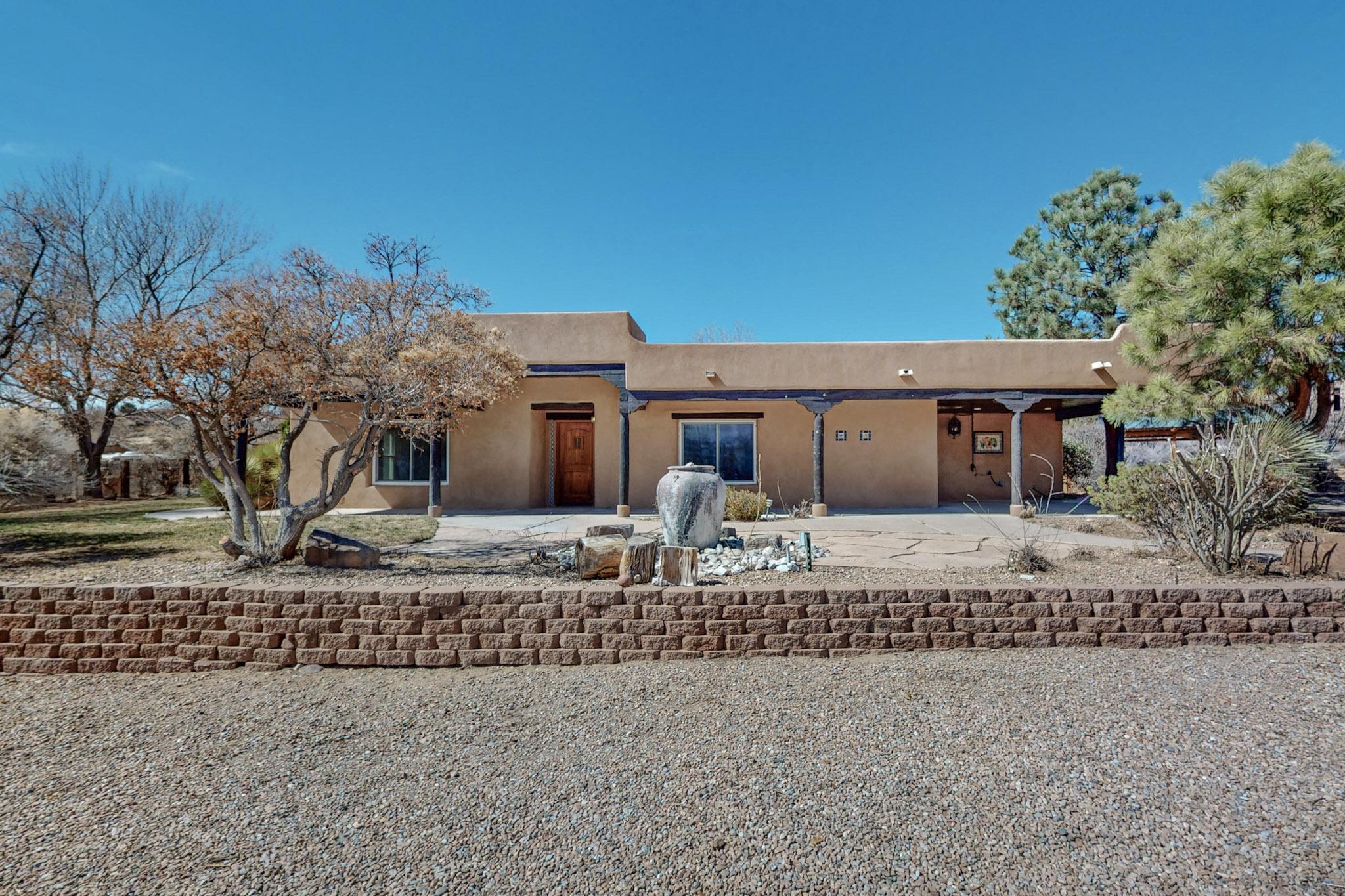 Welcome to your serene oasis in Corrales! This authentic Adobe gem boasts 2 living areas, 3 Kiva fireplaces, formal dining, study, and hardwood floors. Skylights illuminate the wood ceilings, while Talavera accents add flair. The master suite features a private portal and bonus room. Outside, enjoy mountain views, a kiva fireplace, lush garden, fruit trees, and gated entrance. This property is a real retreat for birds and wildlife, creating a biodiverse paradise. Within the coveted Corrales school district. Contact us for a viewing today!